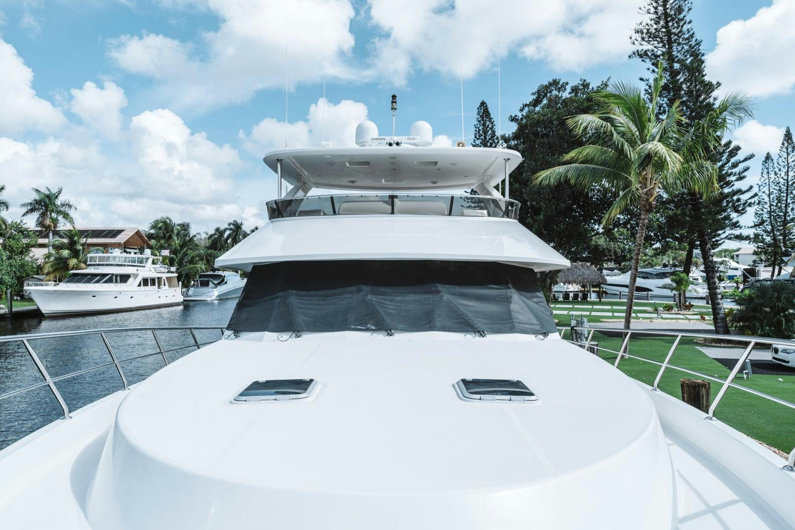 a white boat on a body of water with a white building in the background aboard SKULLDUGGERY Yacht for Sale