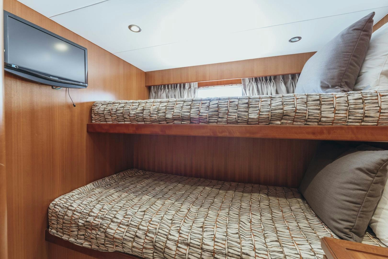 a bed with a television on the wall aboard SKULLDUGGERY Yacht for Sale