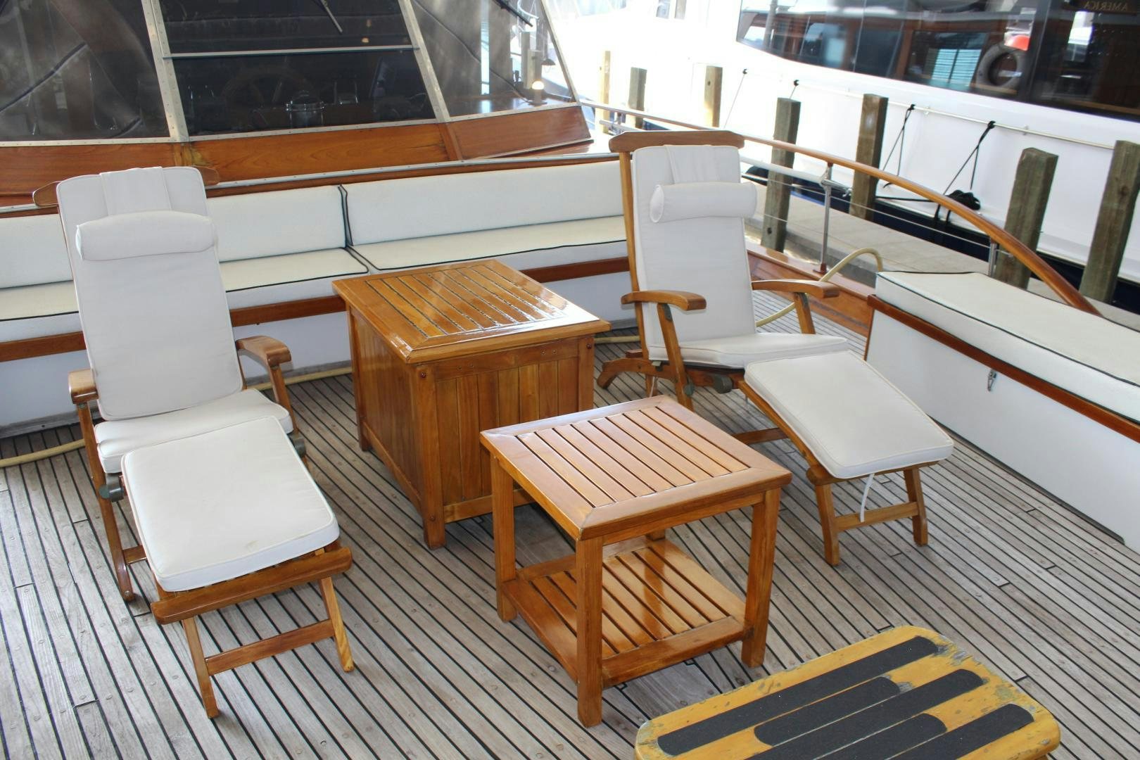a table and chairs on a boat aboard AMERICA Yacht for Sale