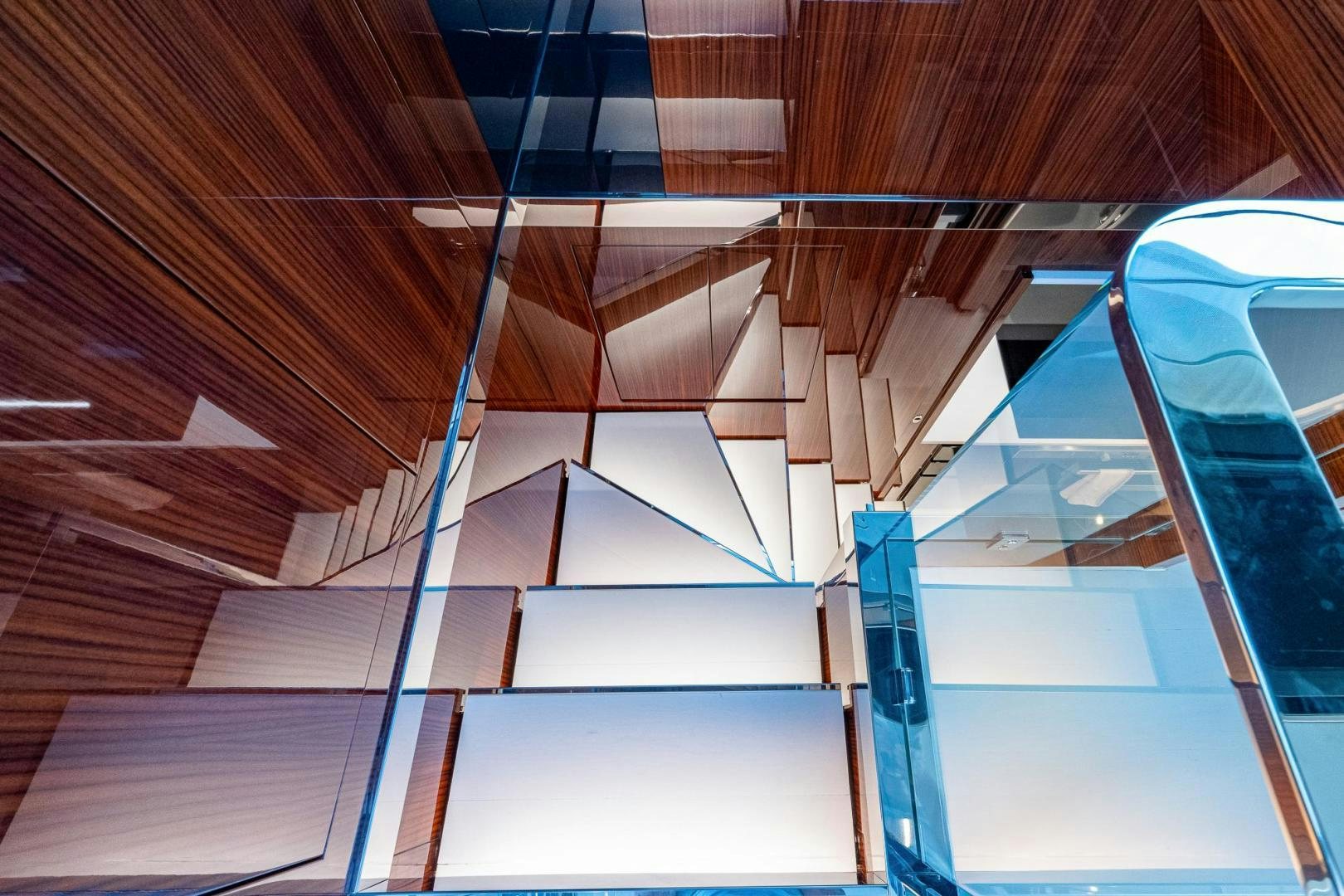 a wooden staircase with blue railings aboard LISOLO Yacht for Sale