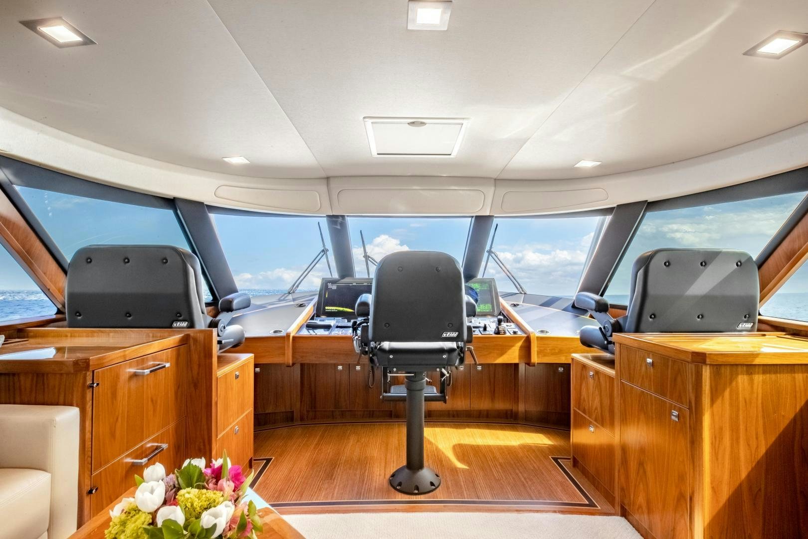 inside of a vehicle with a desk and chairs and a computer on the desk aboard POMPINA Yacht for Sale