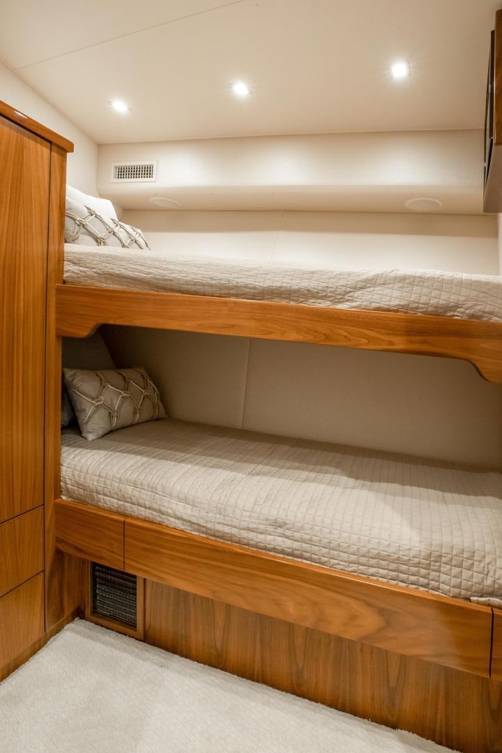 a bed with a wooden headboard aboard POMPINA Yacht for Sale