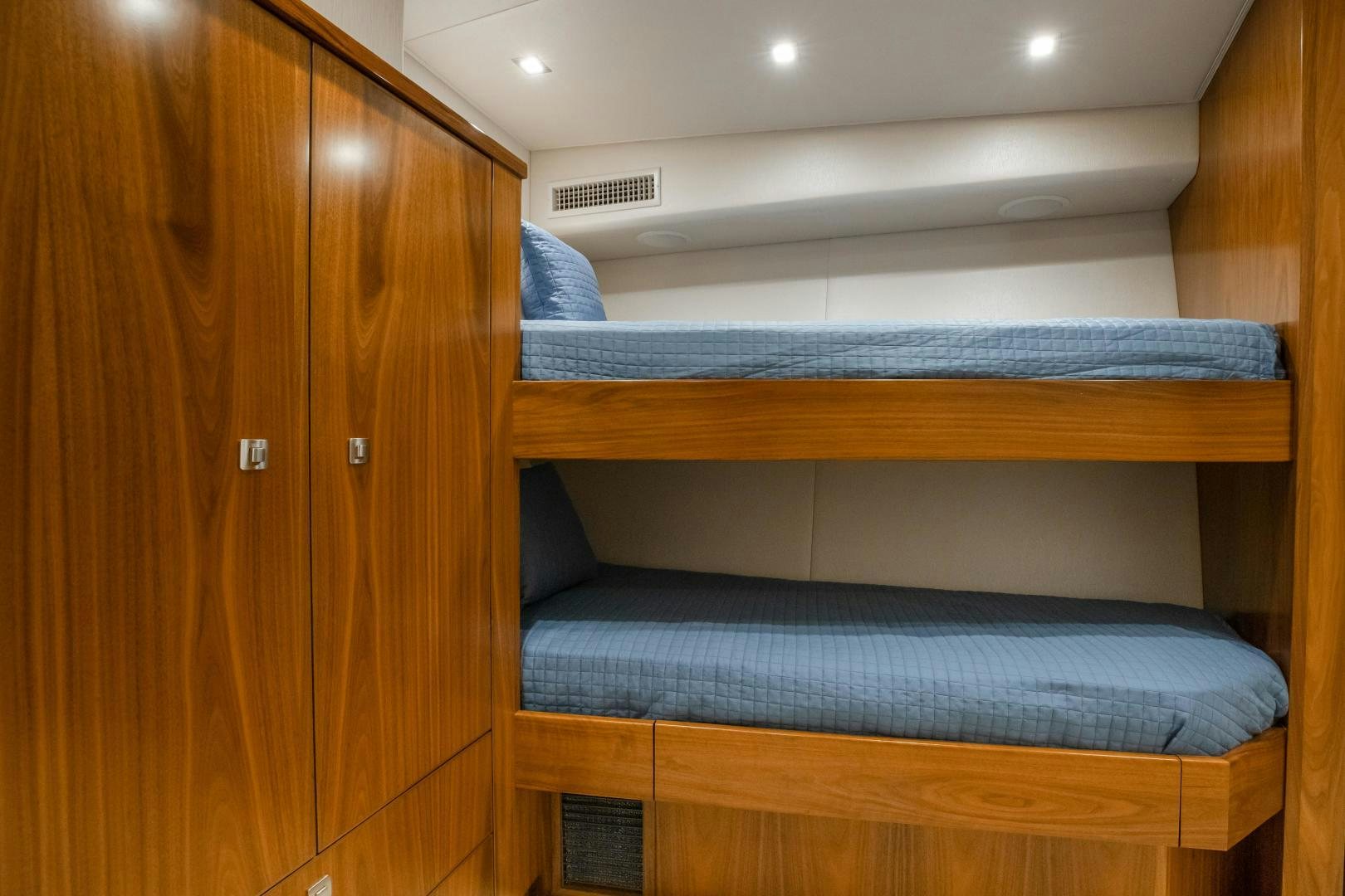 a bed with a wooden headboard aboard POMPINA Yacht for Sale