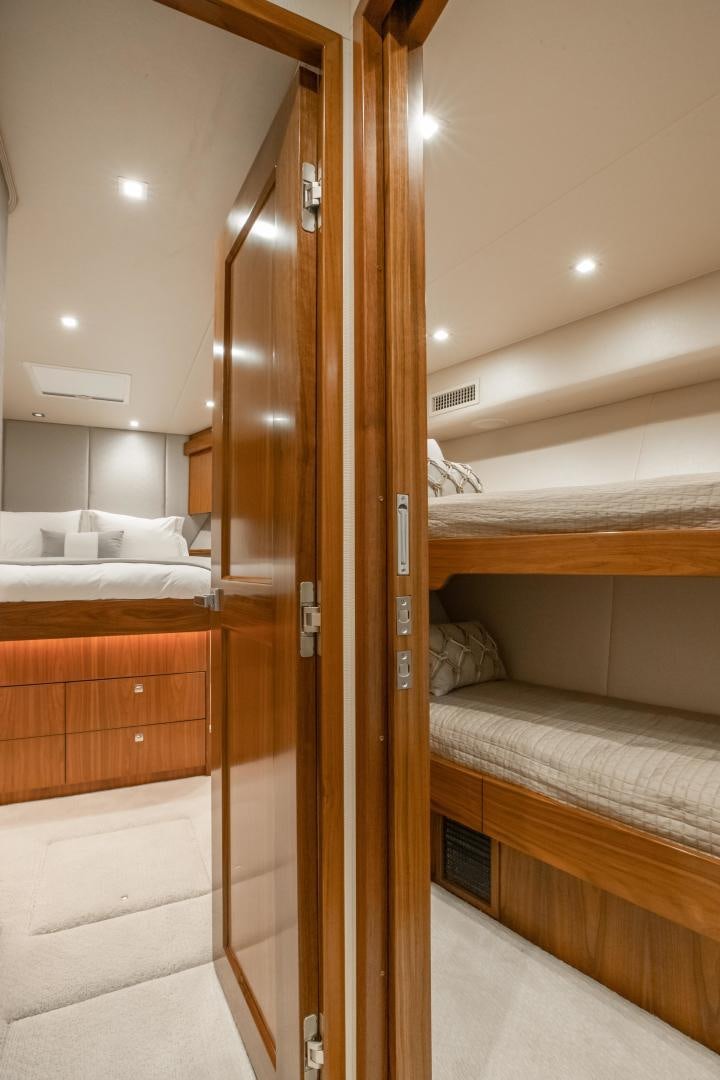 a room with a bed and a wood door aboard POMPINA Yacht for Sale