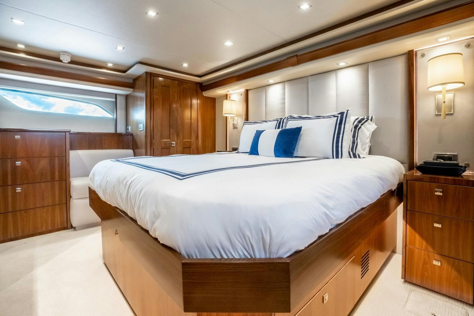 a bed with blue and white pillows aboard POMPINA Yacht for Sale