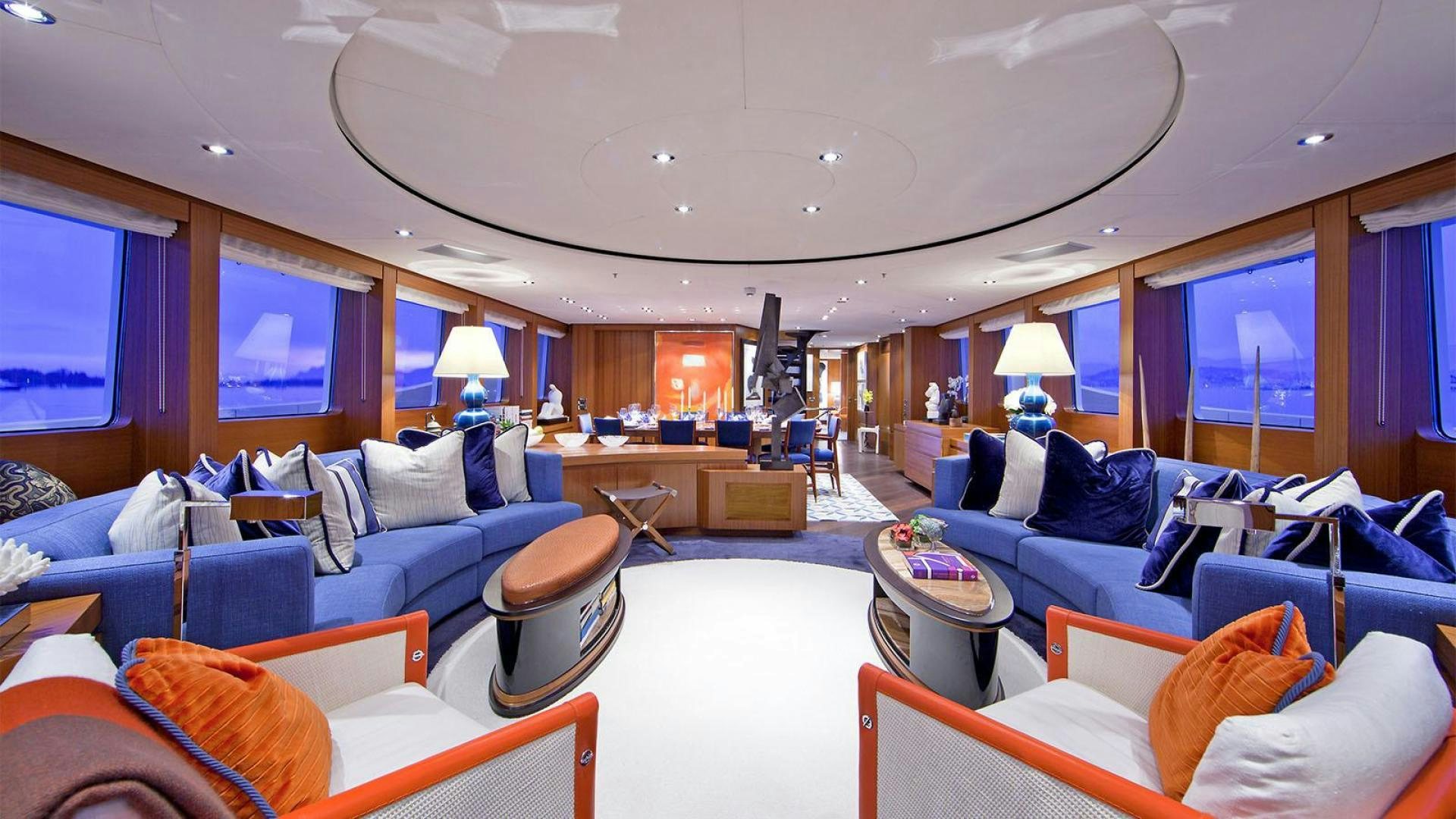 a living room with a blue couch and a large window aboard SNOWBIRD Yacht for Sale