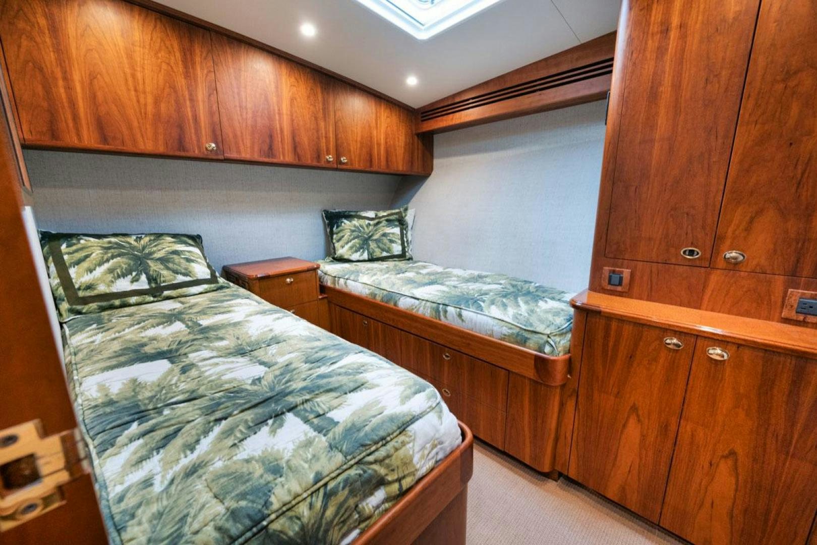 a bedroom with a bed and wooden cabinets aboard Gina Lisa Yacht for Sale