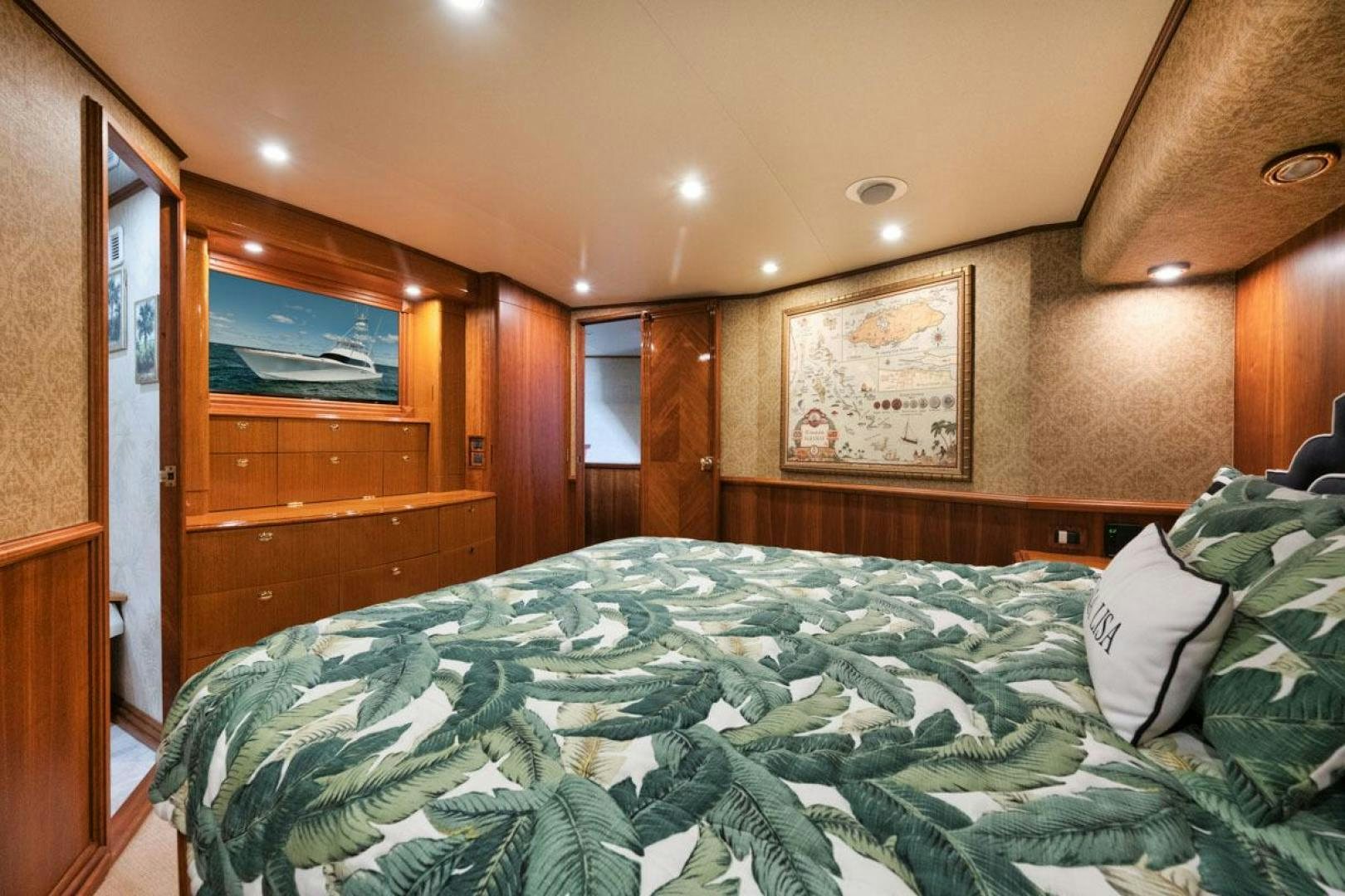 a bed with a green comforter aboard Gina Lisa Yacht for Sale