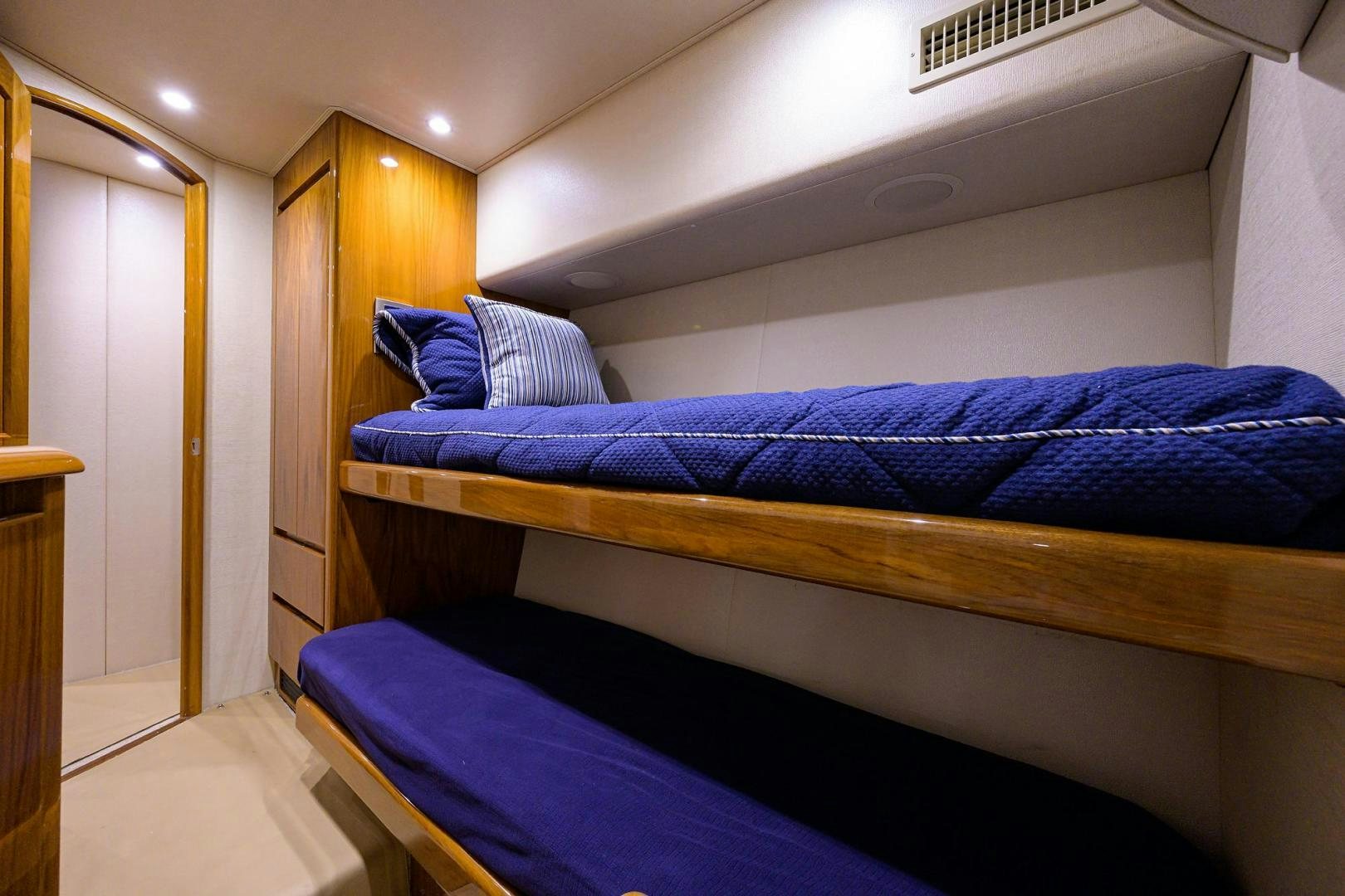 a bed with blue sheets aboard TORO Yacht for Sale