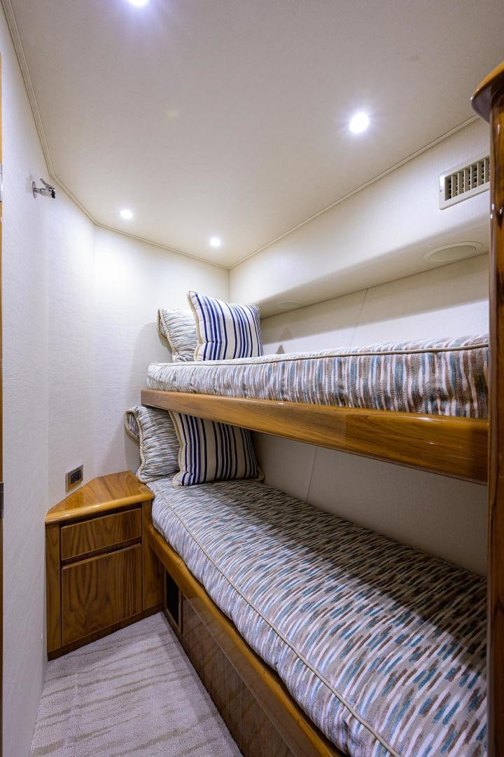 a bed with a wood headboard aboard TORO Yacht for Sale