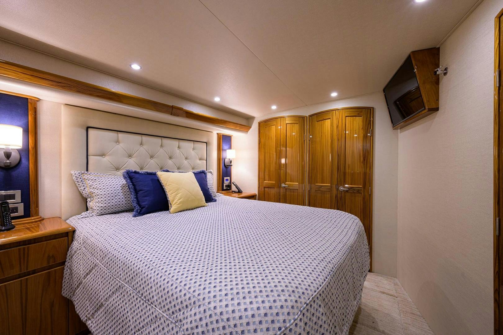 a bed with blue and white pillows aboard TORO Yacht for Sale