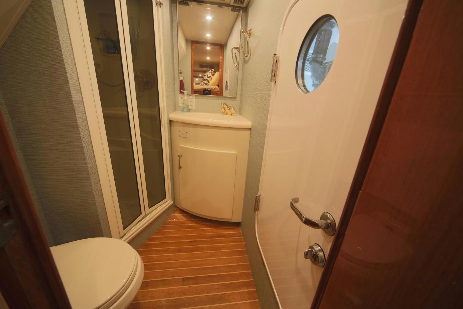 a bathroom with a toilet and a mirror aboard LUCILLE Yacht for Sale