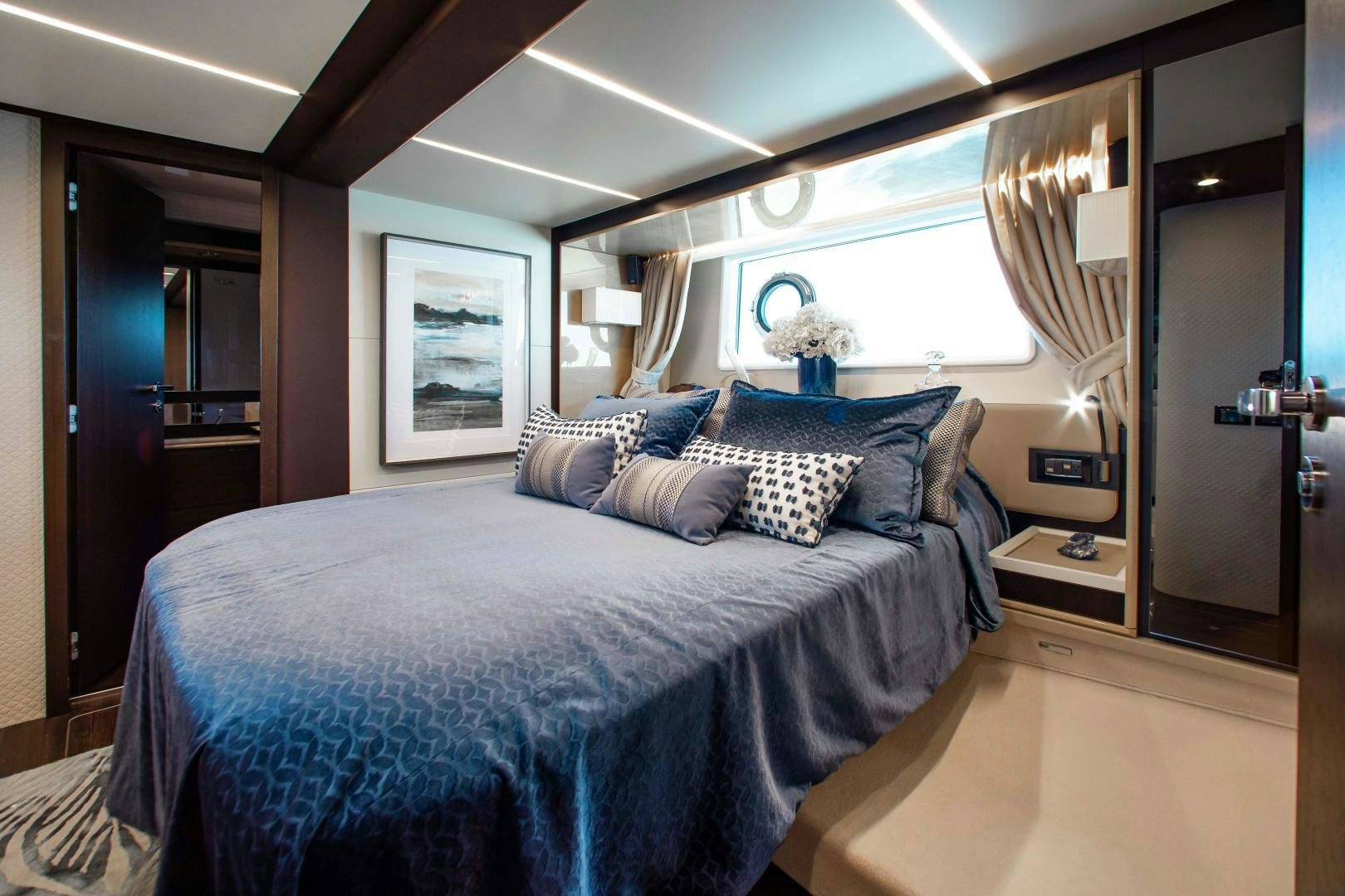 a bed with blue sheets aboard Queen Mara Yacht for Sale