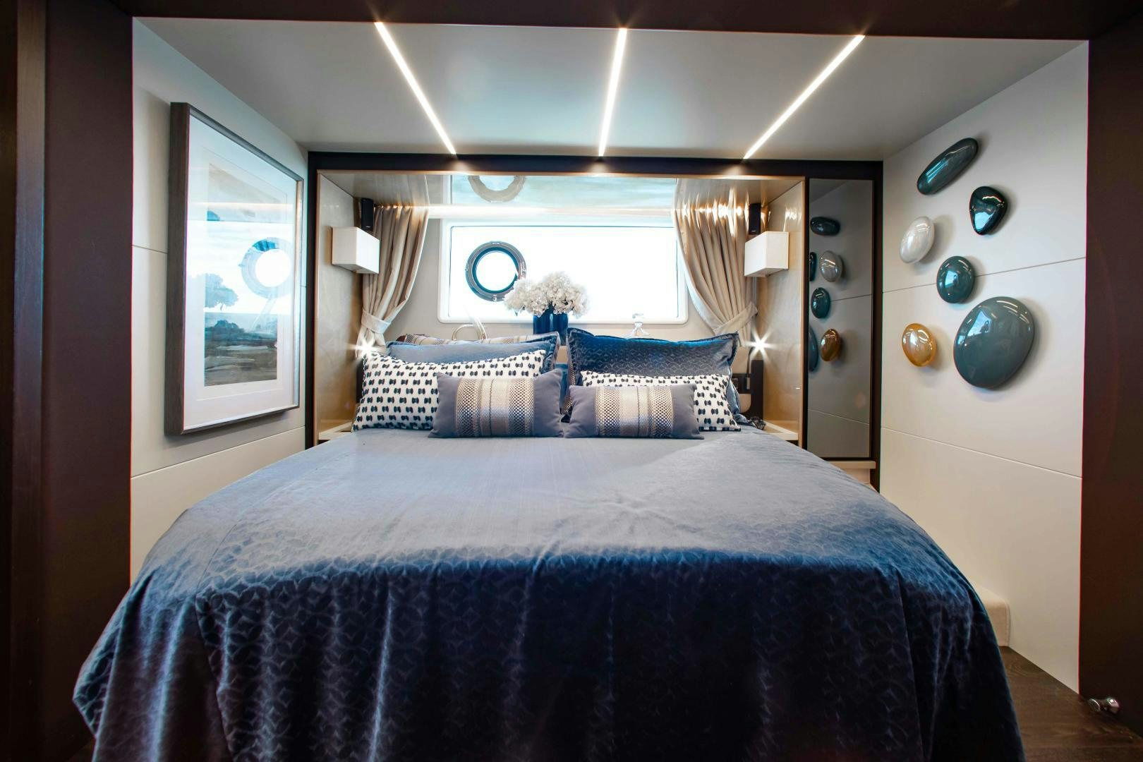 a bed with blue sheets aboard Queen Mara Yacht for Sale