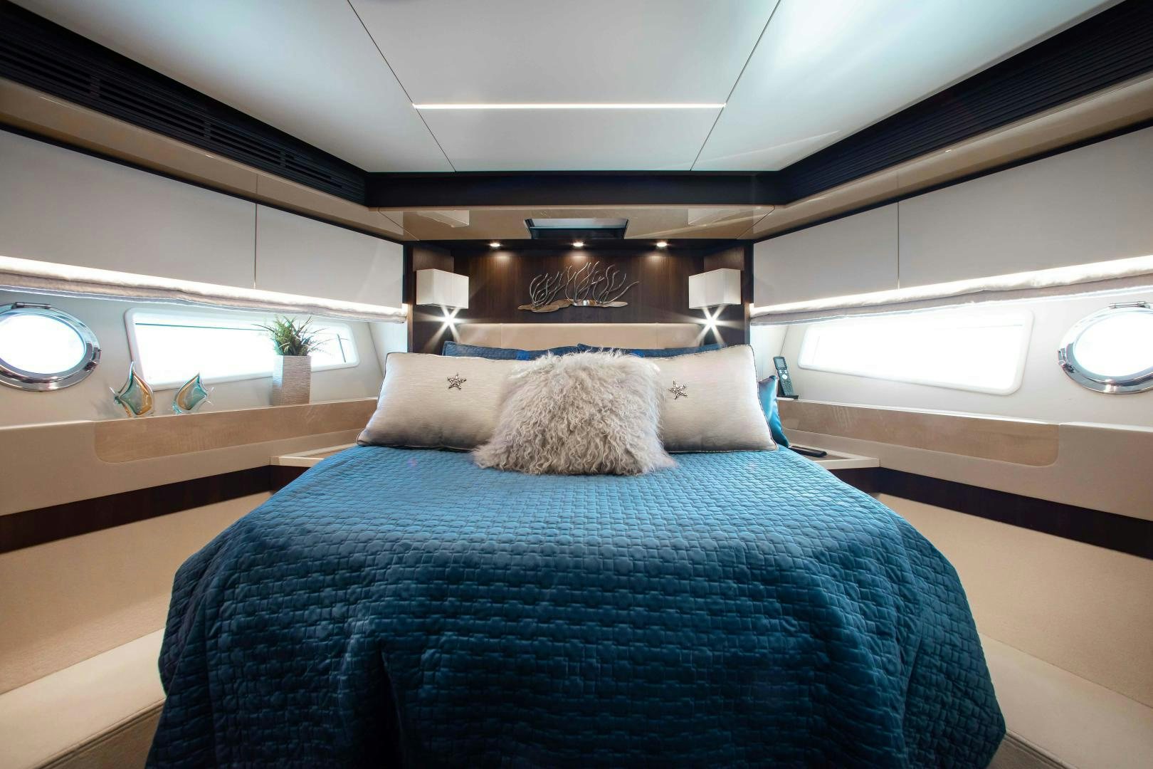a bed with a blue comforter aboard Queen Mara Yacht for Sale