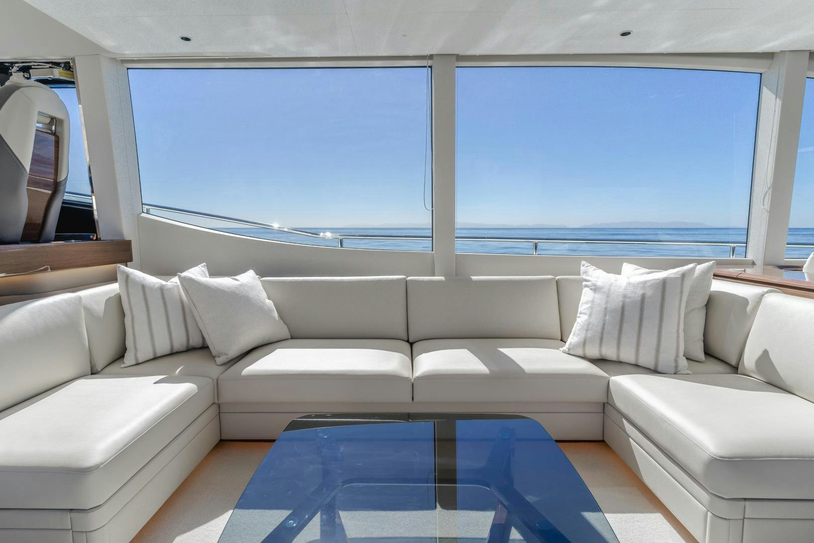 a white couch with a blue rug in front of a large blue window aboard Mad Betty 2.0 Yacht for Sale