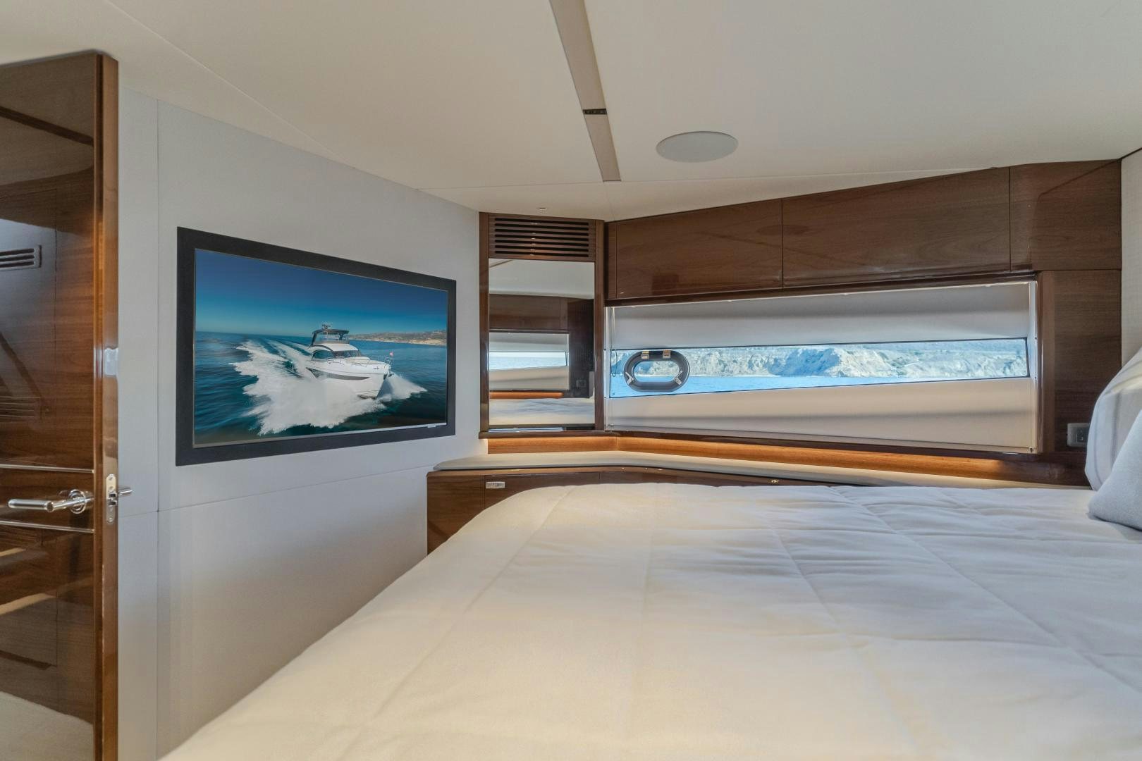 a bed with a television on the wall aboard Mad Betty 2.0 Yacht for Sale