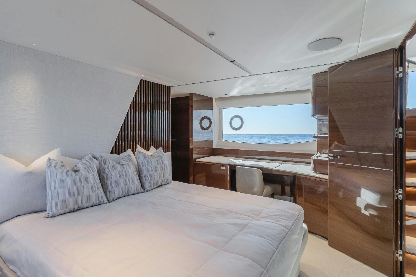 a bed with a desk and a window aboard Mad Betty 2.0 Yacht for Sale