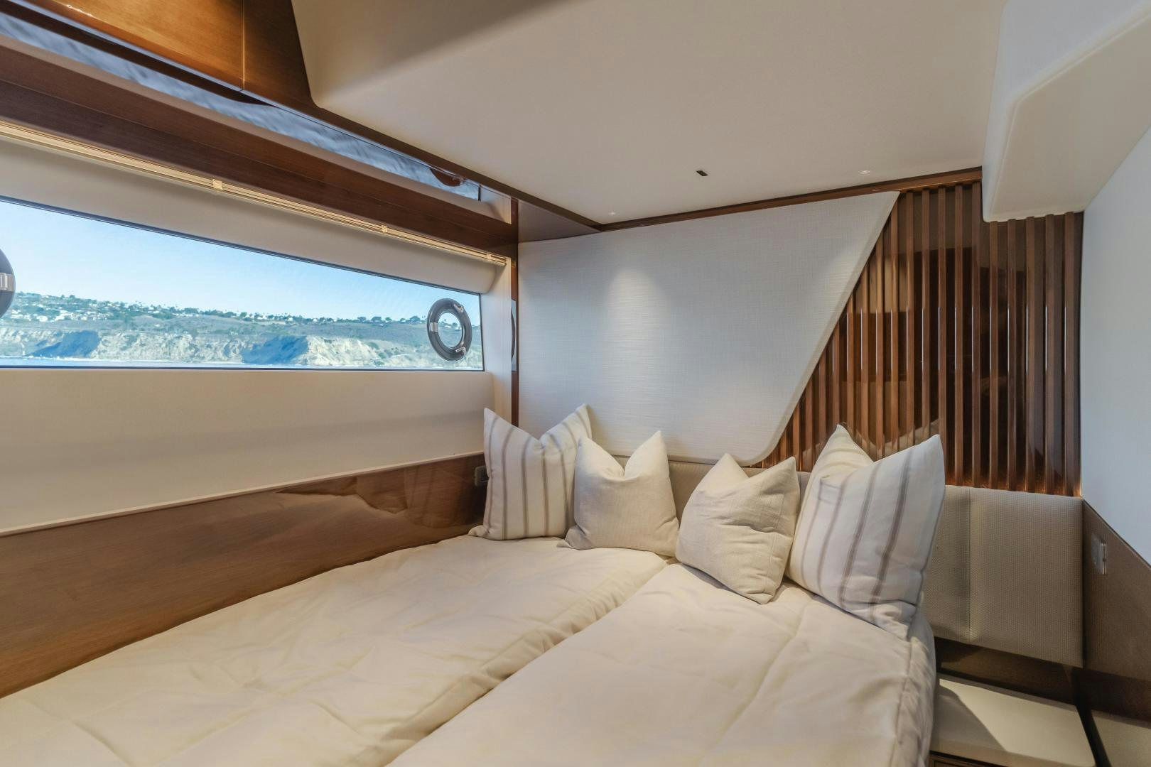 a bed with a large window aboard Mad Betty 2.0 Yacht for Sale