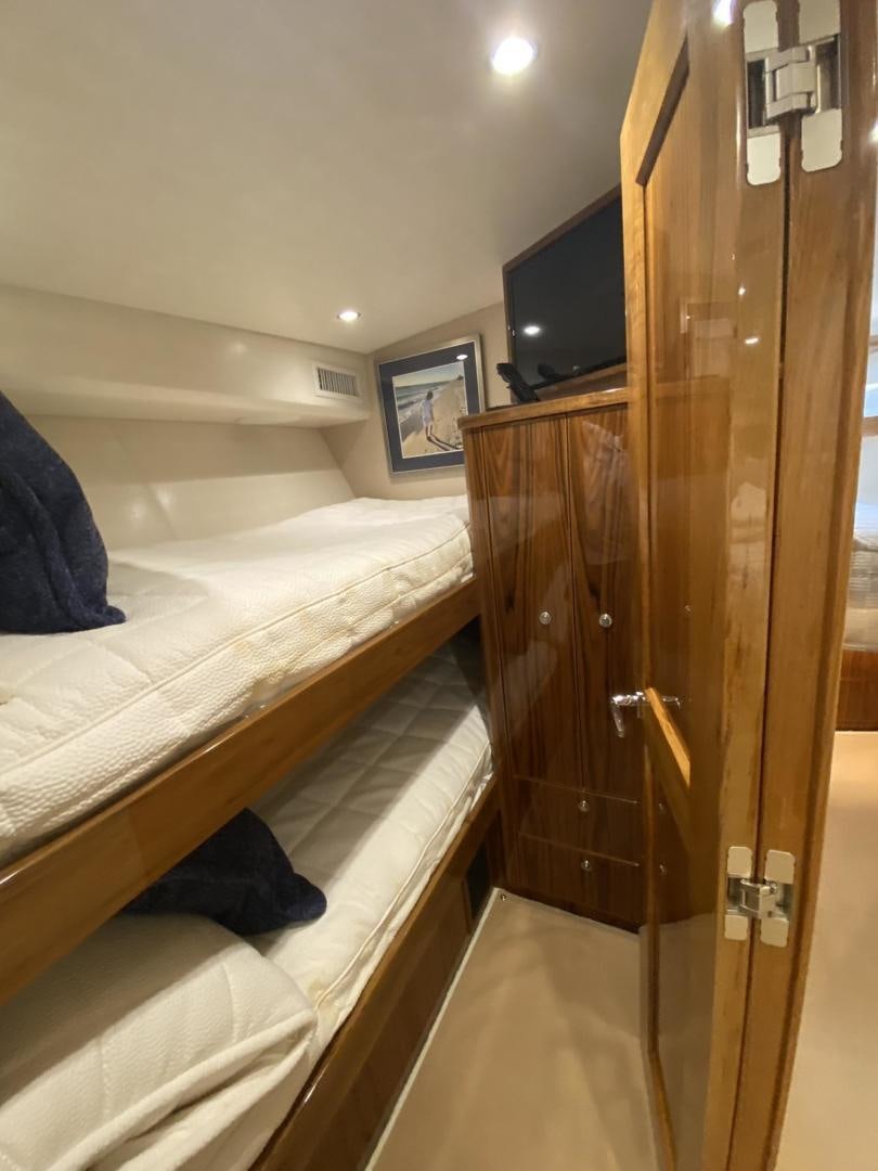 a room with a bed and a television aboard Make It Happen Yacht for Sale