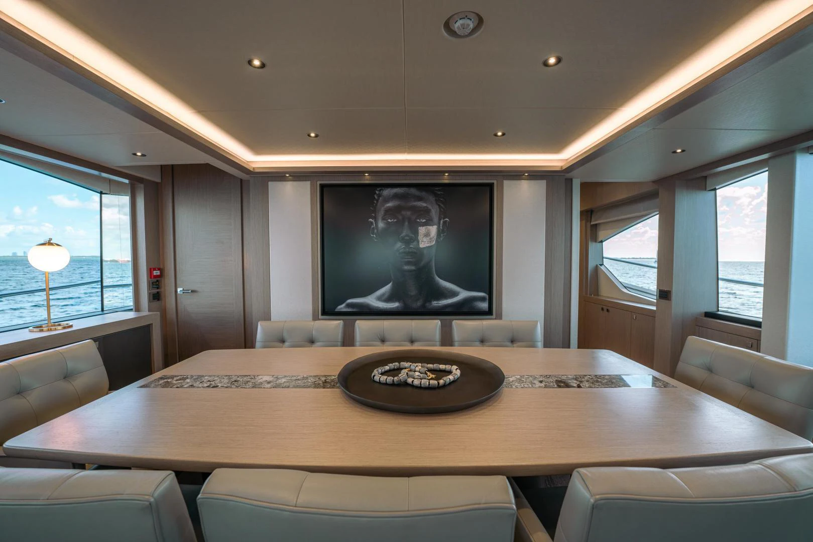 a television on a wall in a room with a table and chairs aboard EOS Yacht for Sale