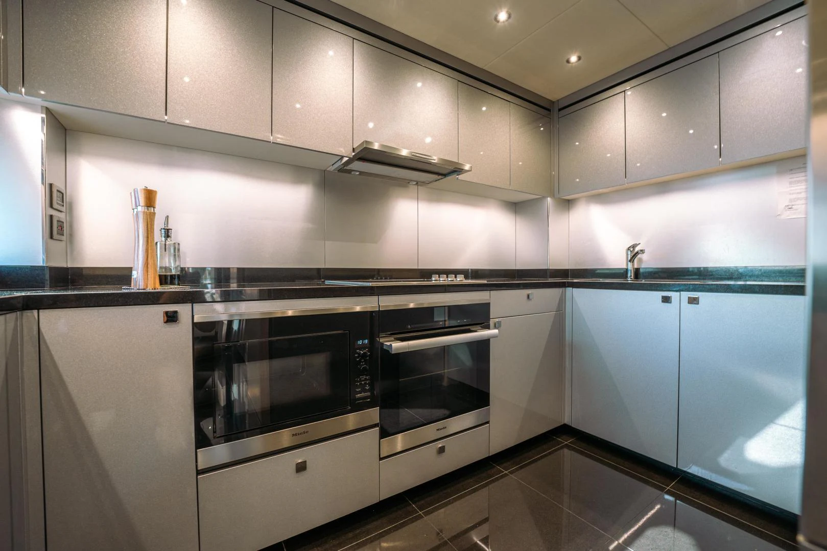 a kitchen with white cabinets aboard EOS Yacht for Sale