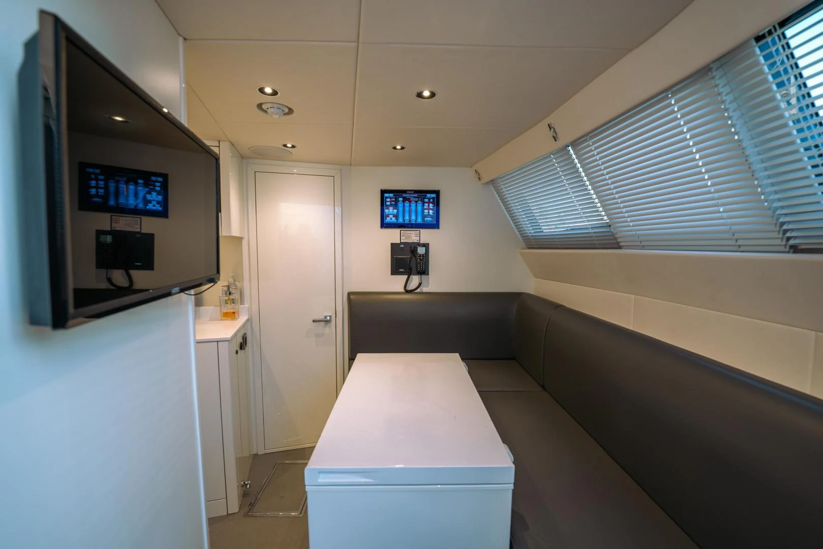 a room with a tv and a table aboard EOS Yacht for Sale