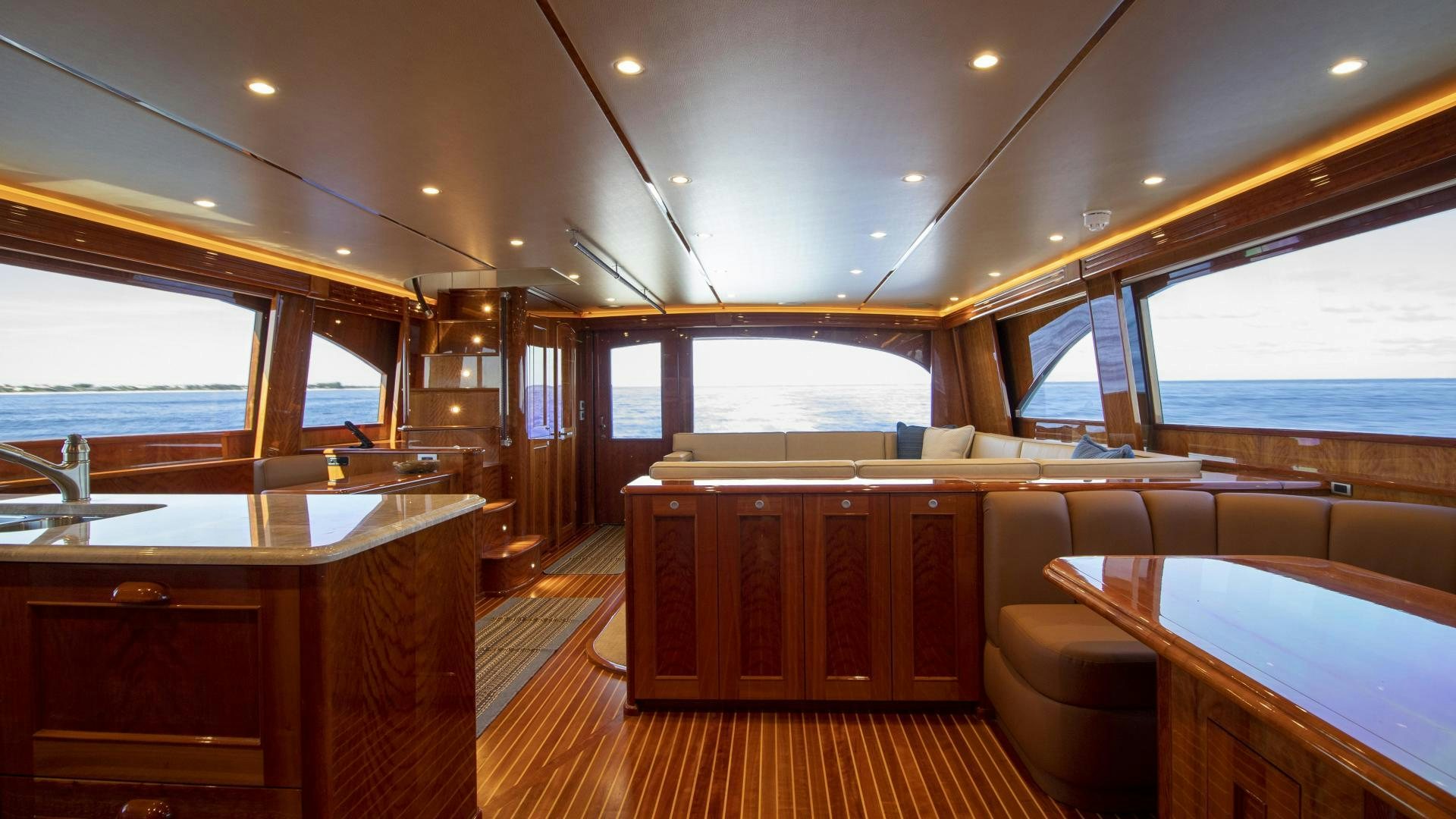 a room with a wood floor and a wood table with a large window aboard VICTORY Yacht for Sale