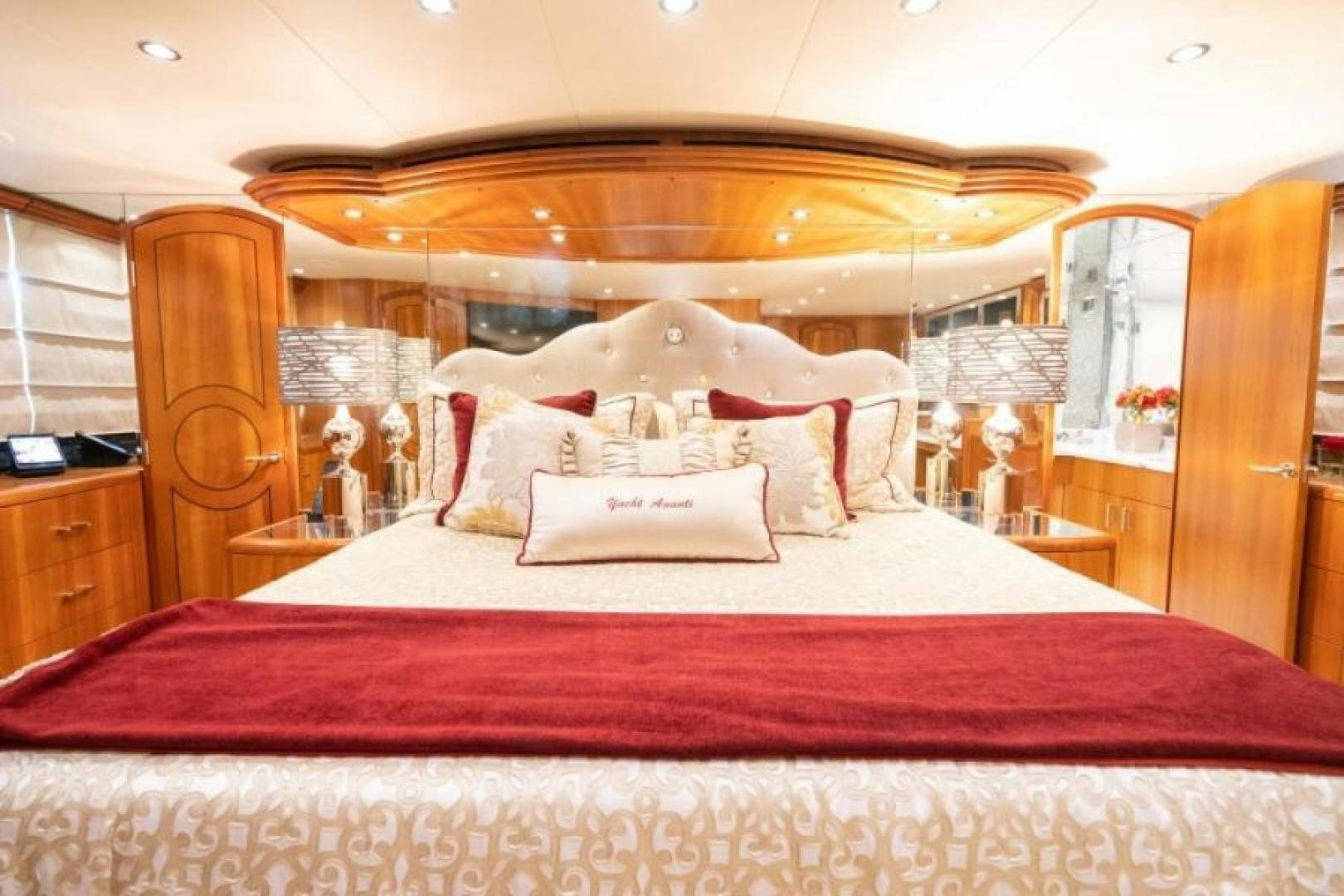 a large bed with a red comforter and a large mirror aboard DANIELLE Yacht for Sale