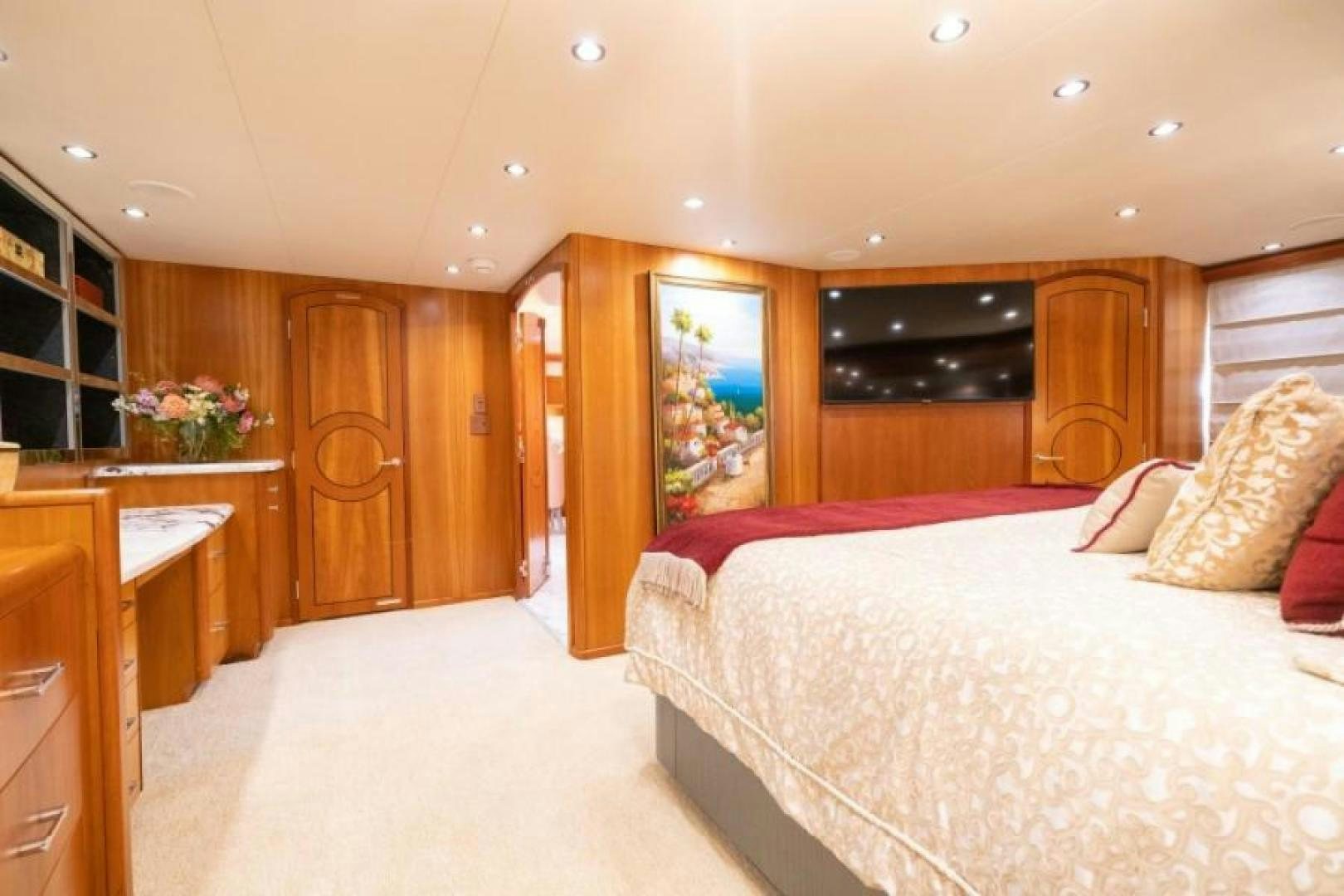 a bedroom with a bed and a wood cabinet aboard DANIELLE Yacht for Sale