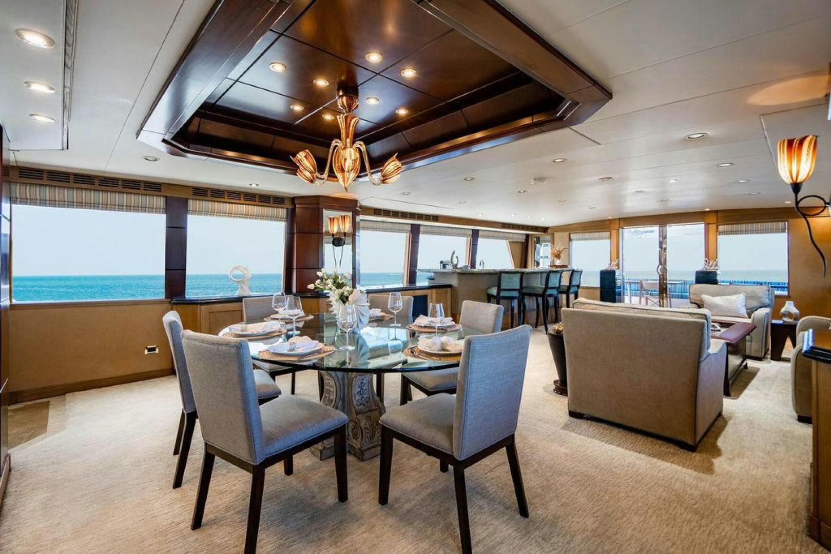 a large room with a table and chairs and a chandelier aboard NORTH COAST 120 Yacht for Sale