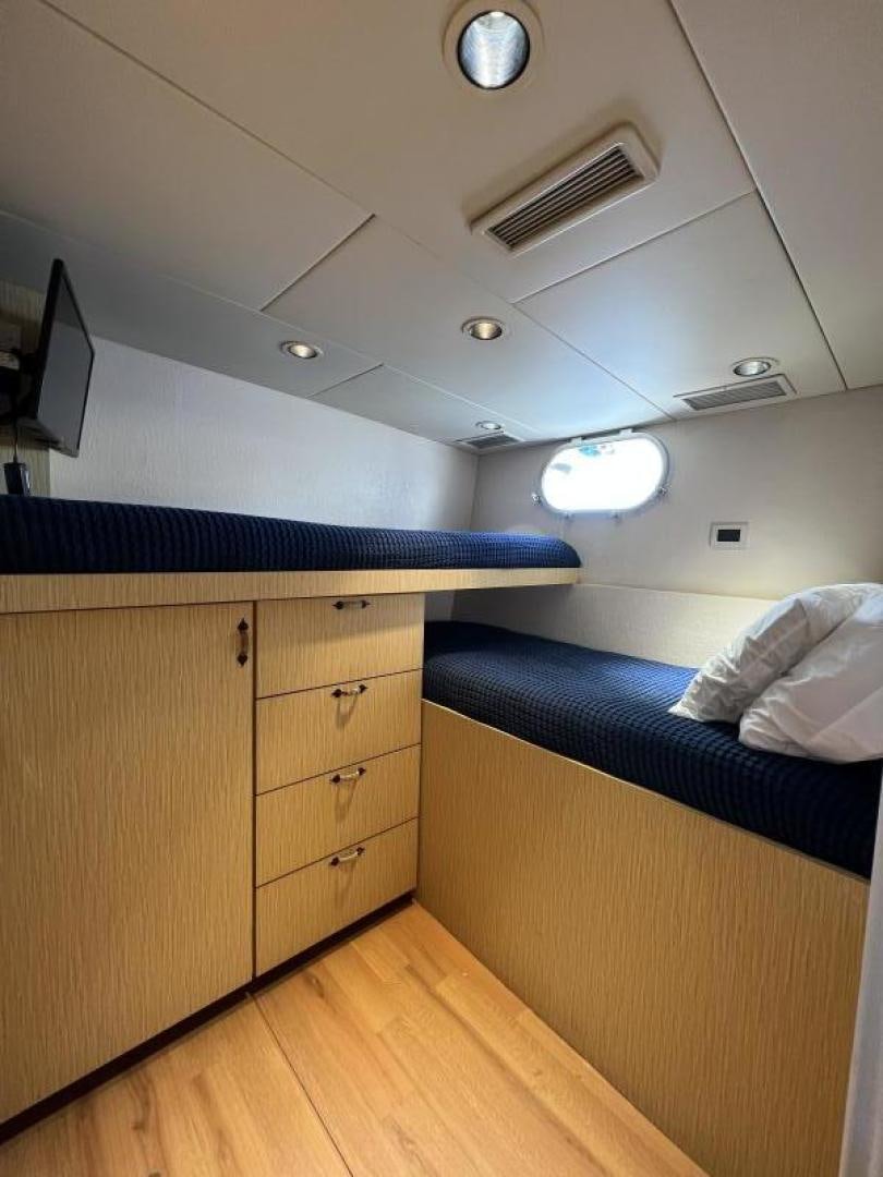 a room with a bed and a desk aboard NORTH COAST 120 Yacht for Sale