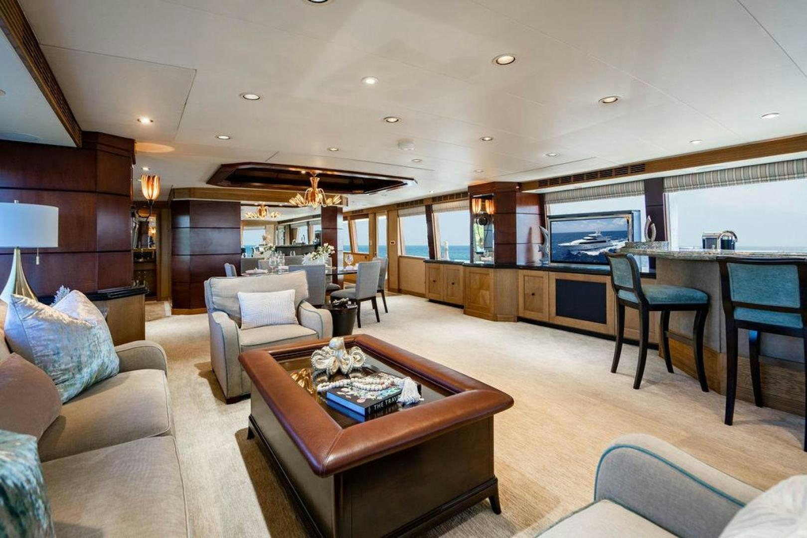 a living room with a large open kitchen and dining area aboard NORTH COAST 120 Yacht for Sale