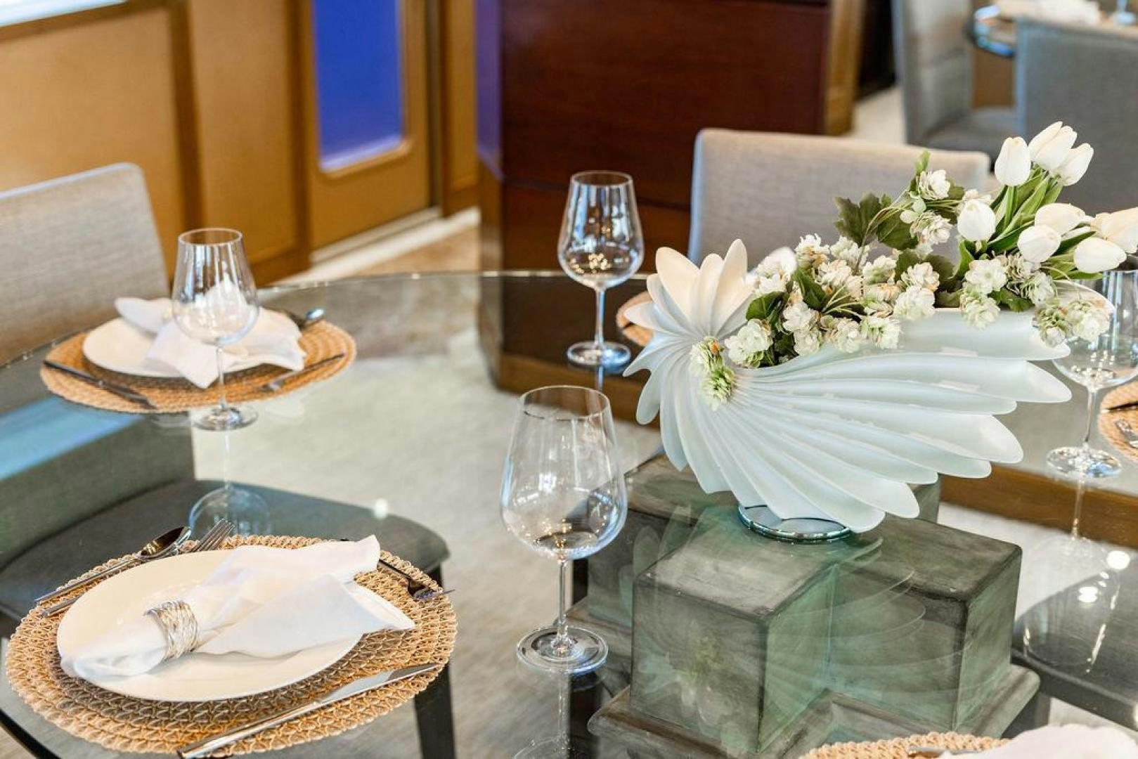 a table with a plate of food and glasses on it aboard NORTH COAST 120 Yacht for Sale