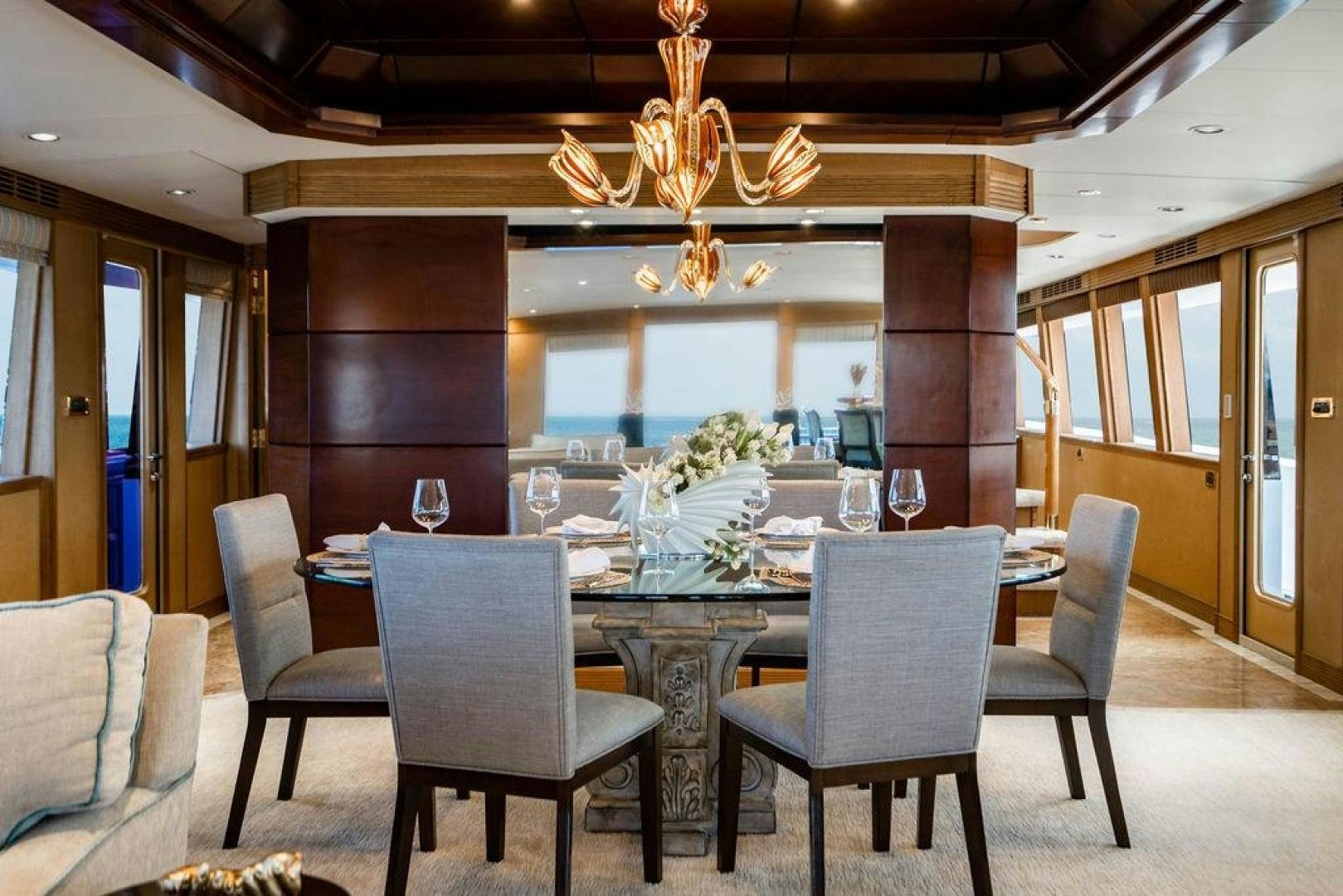 a dining room with a chandelier aboard NORTH COAST 120 Yacht for Sale