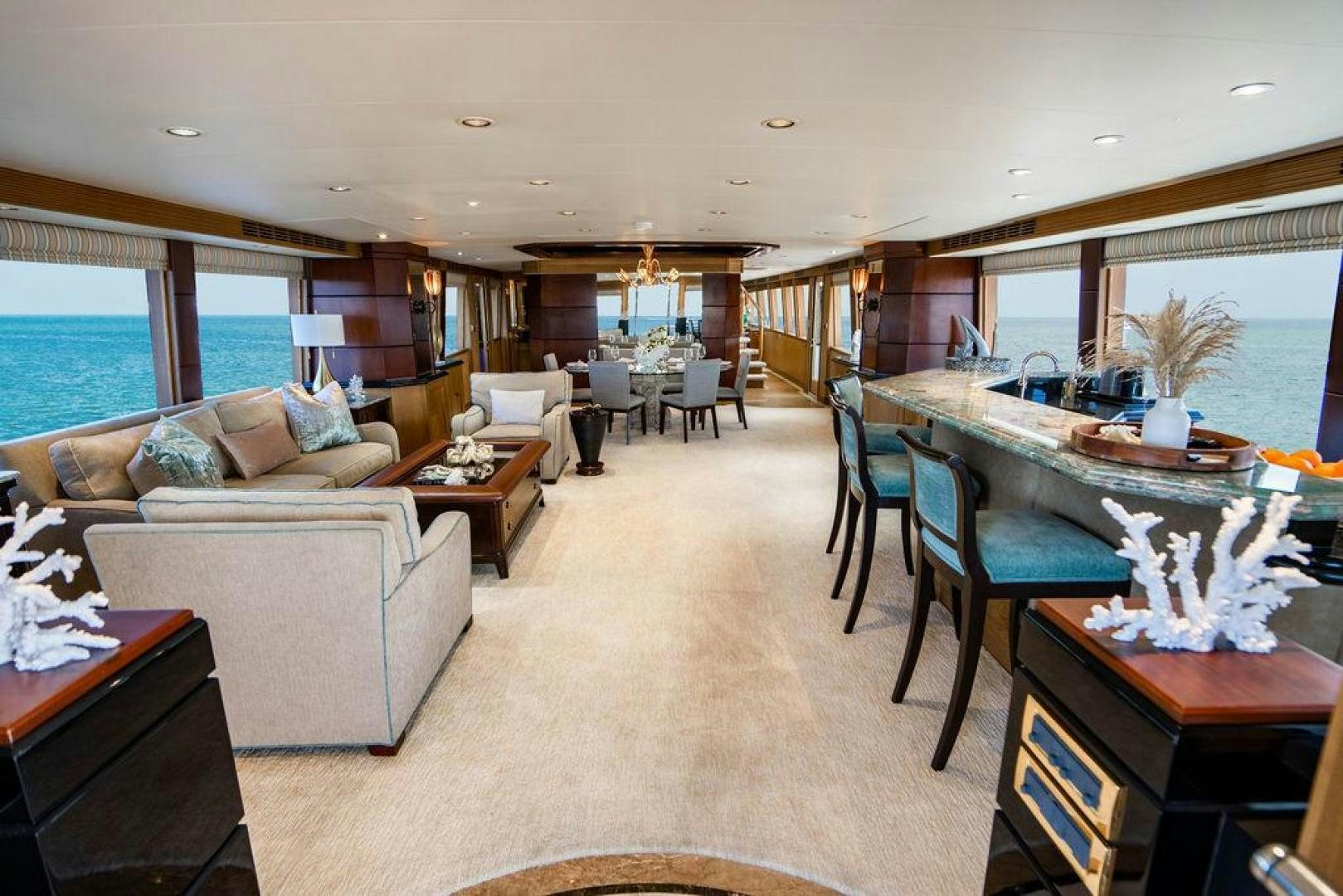 a living room with a large table and couches aboard NORTH COAST 120 Yacht for Sale