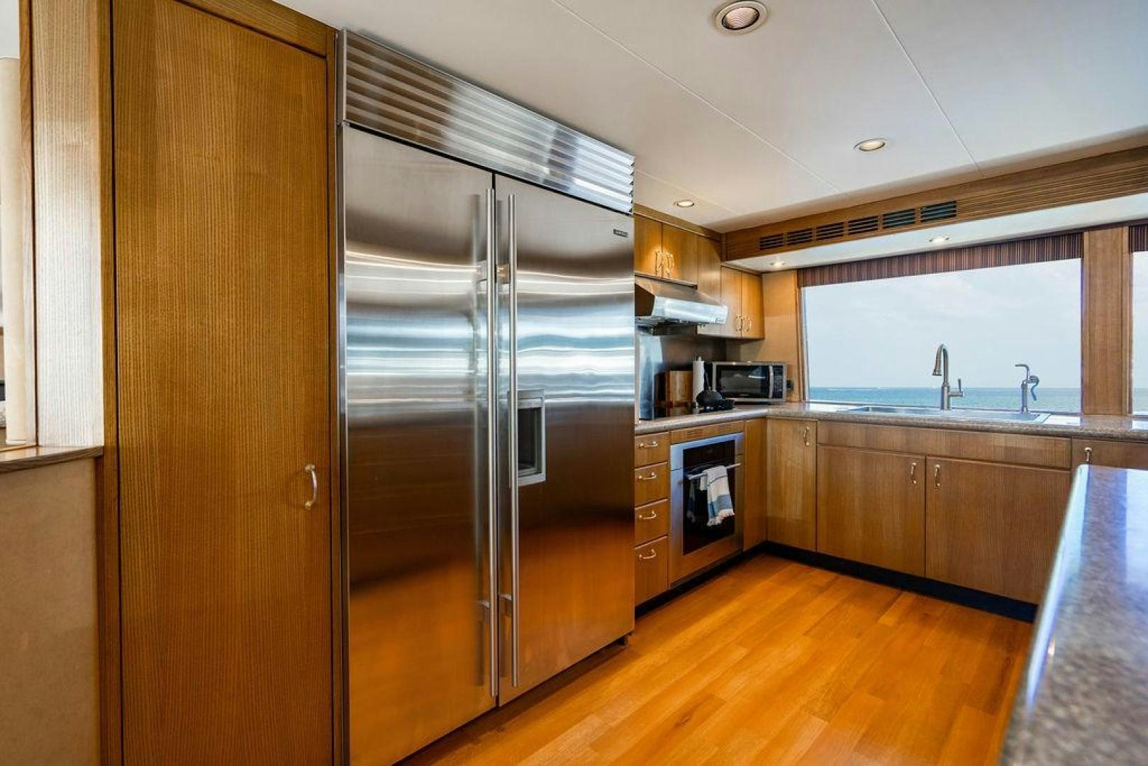 a kitchen with a stainless steel refrigerator aboard NORTH COAST 120 Yacht for Sale