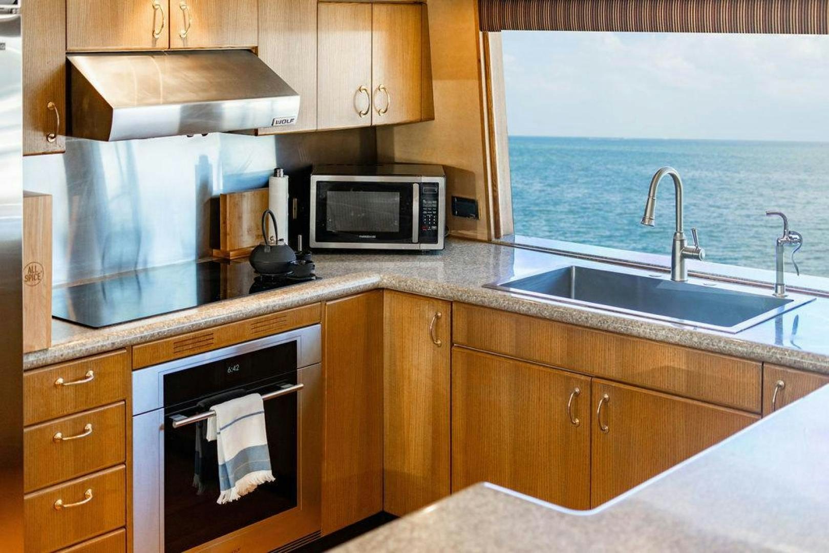 a kitchen with wooden cabinets aboard NORTH COAST 120 Yacht for Sale