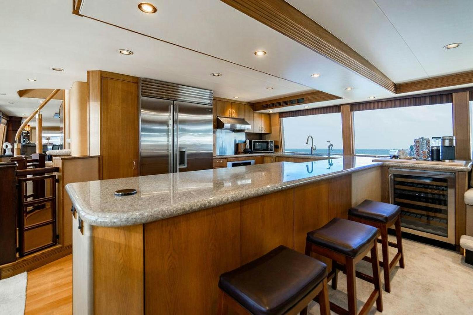 a kitchen with a bar and stools aboard NORTH COAST 120 Yacht for Sale