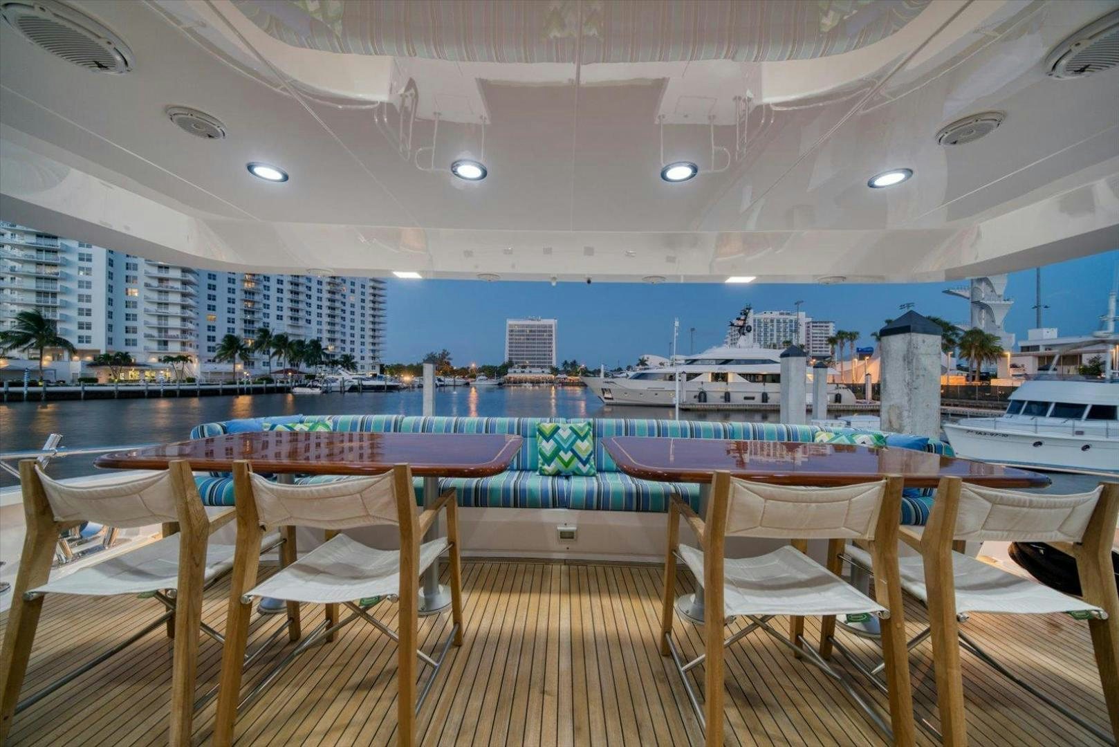 a deck with chairs and tables aboard NORTH COAST 120 Yacht for Sale
