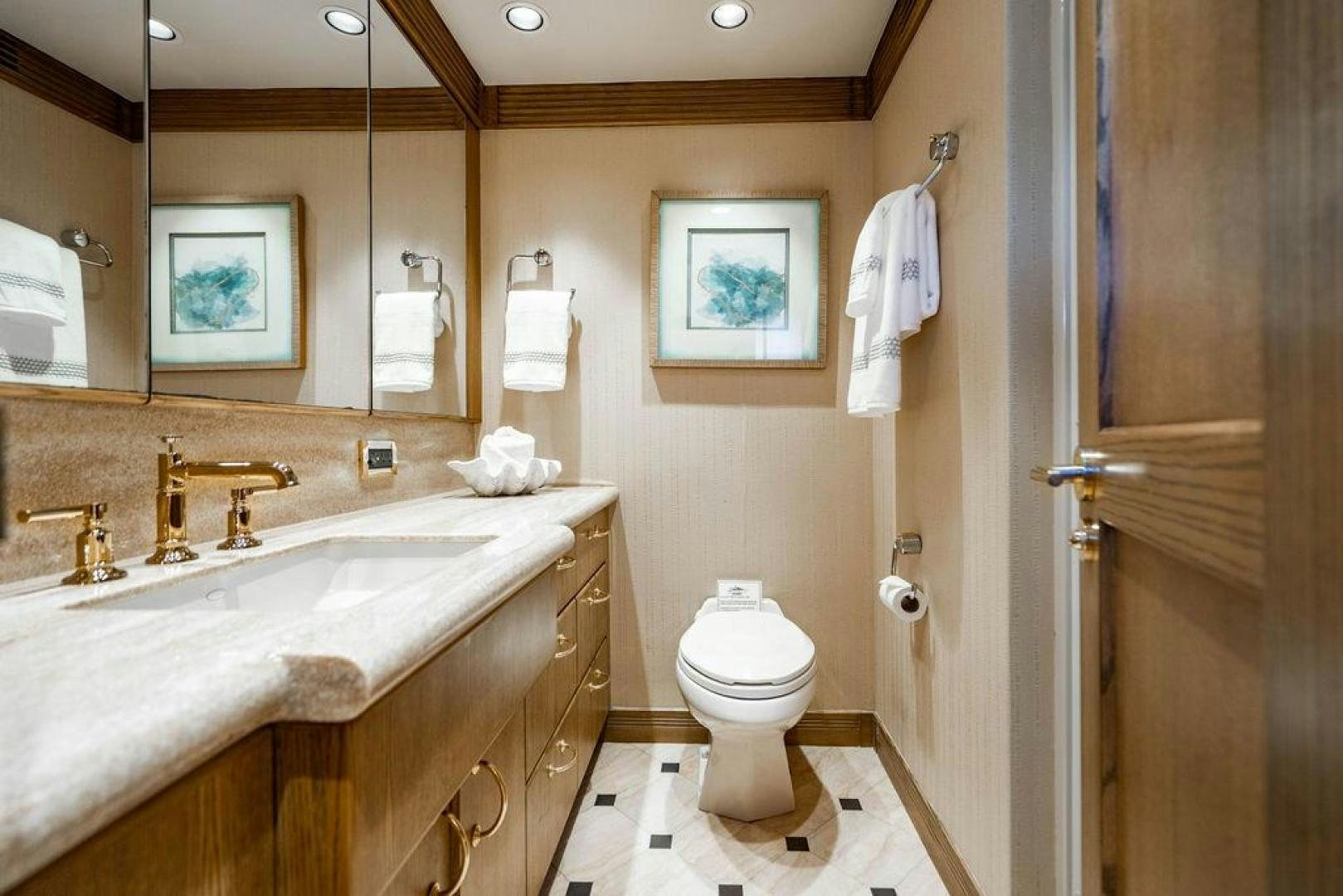 a bathroom with a sink toilet and a mirror aboard NORTH COAST 120 Yacht for Sale