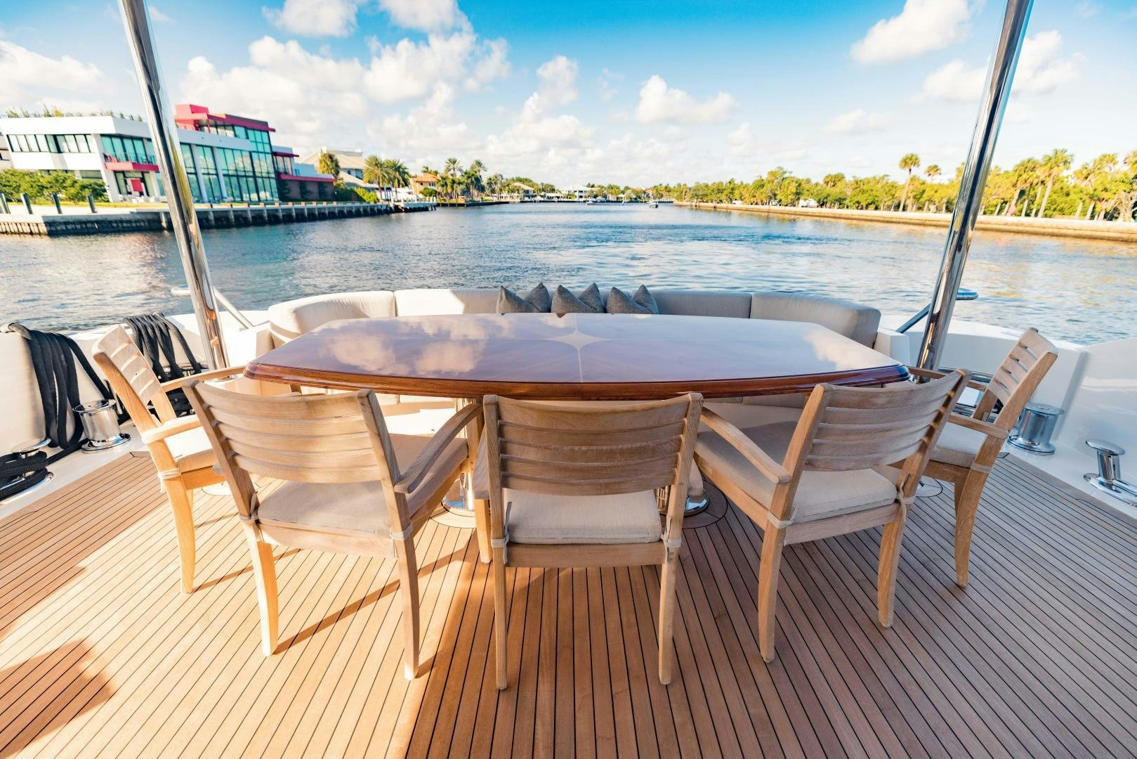 a table and chairs on a deck overlooking a body of water aboard INVICTUS Yacht for Sale