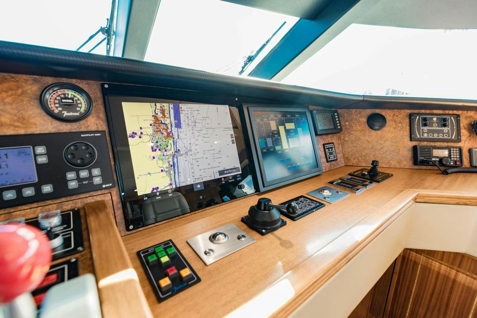 a control panel with a couple of monitors and a game controller aboard INVICTUS Yacht for Sale