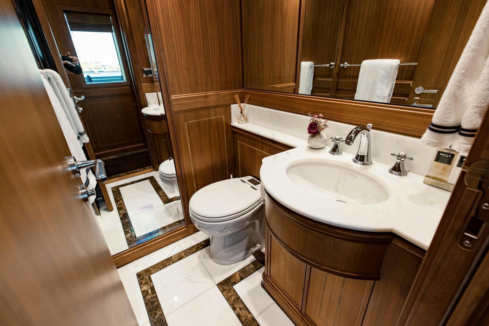 a bathroom with a sink toilet and a mirror aboard INVICTUS Yacht for Sale