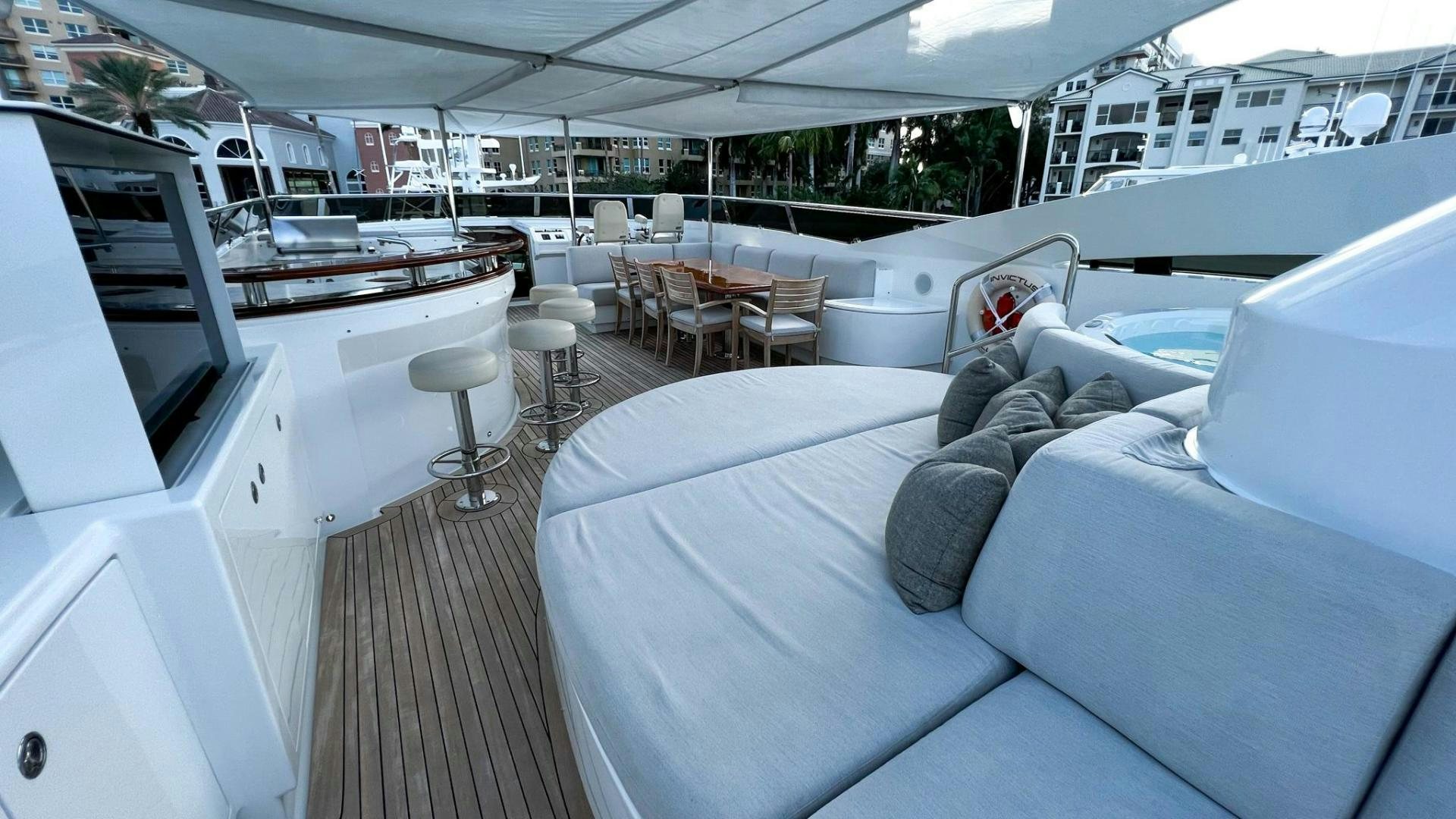 a large white boat with a white bed and a white table aboard INVICTUS Yacht for Sale