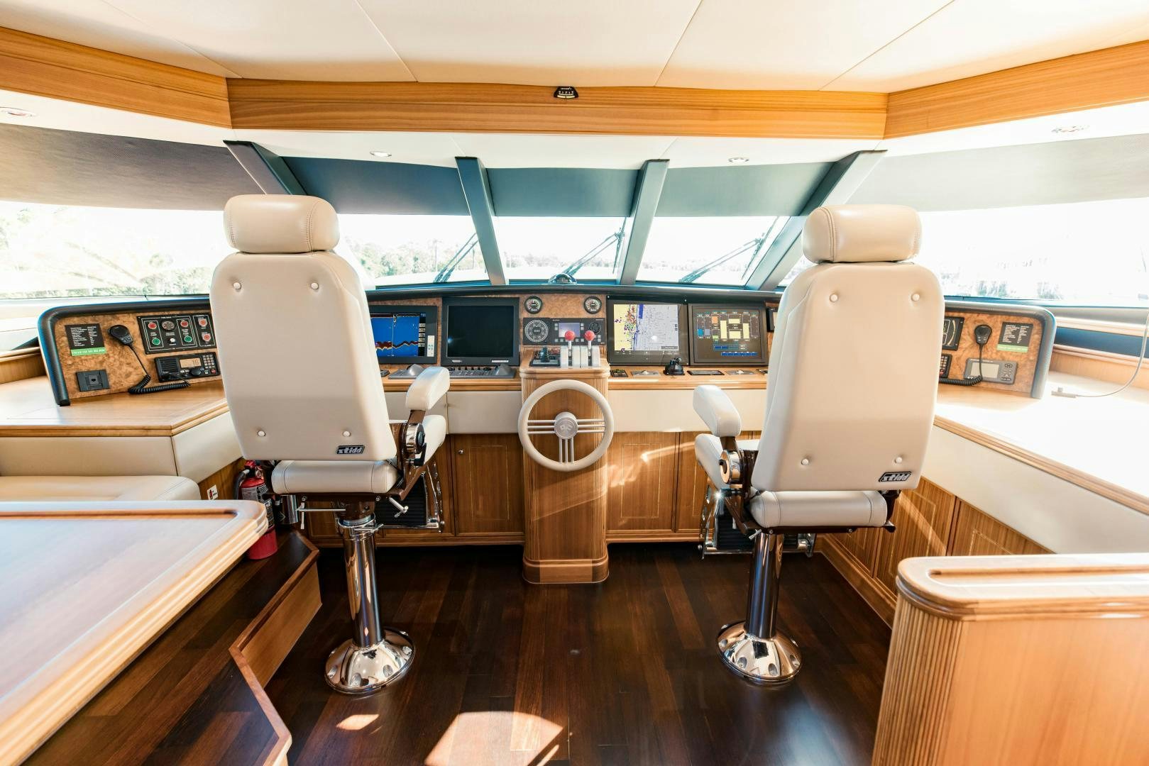 a room with a few chairs and a table with a large window aboard INVICTUS Yacht for Sale