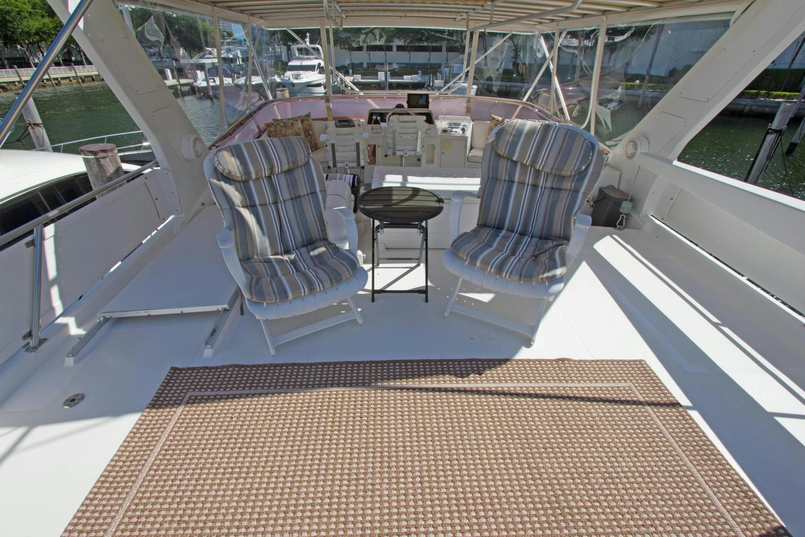 a deck with chairs and a table aboard Seaquest Yacht for Sale
