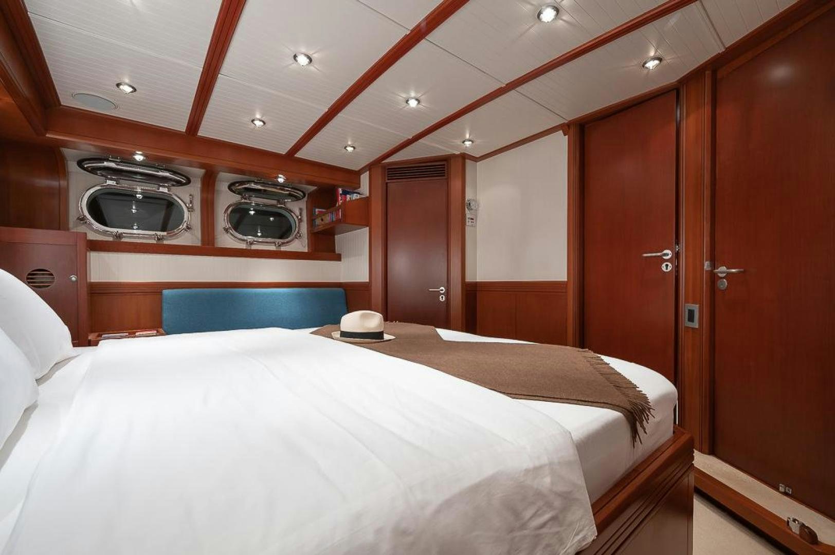 a room with a bed and a wood door aboard CAPELLA Yacht for Sale