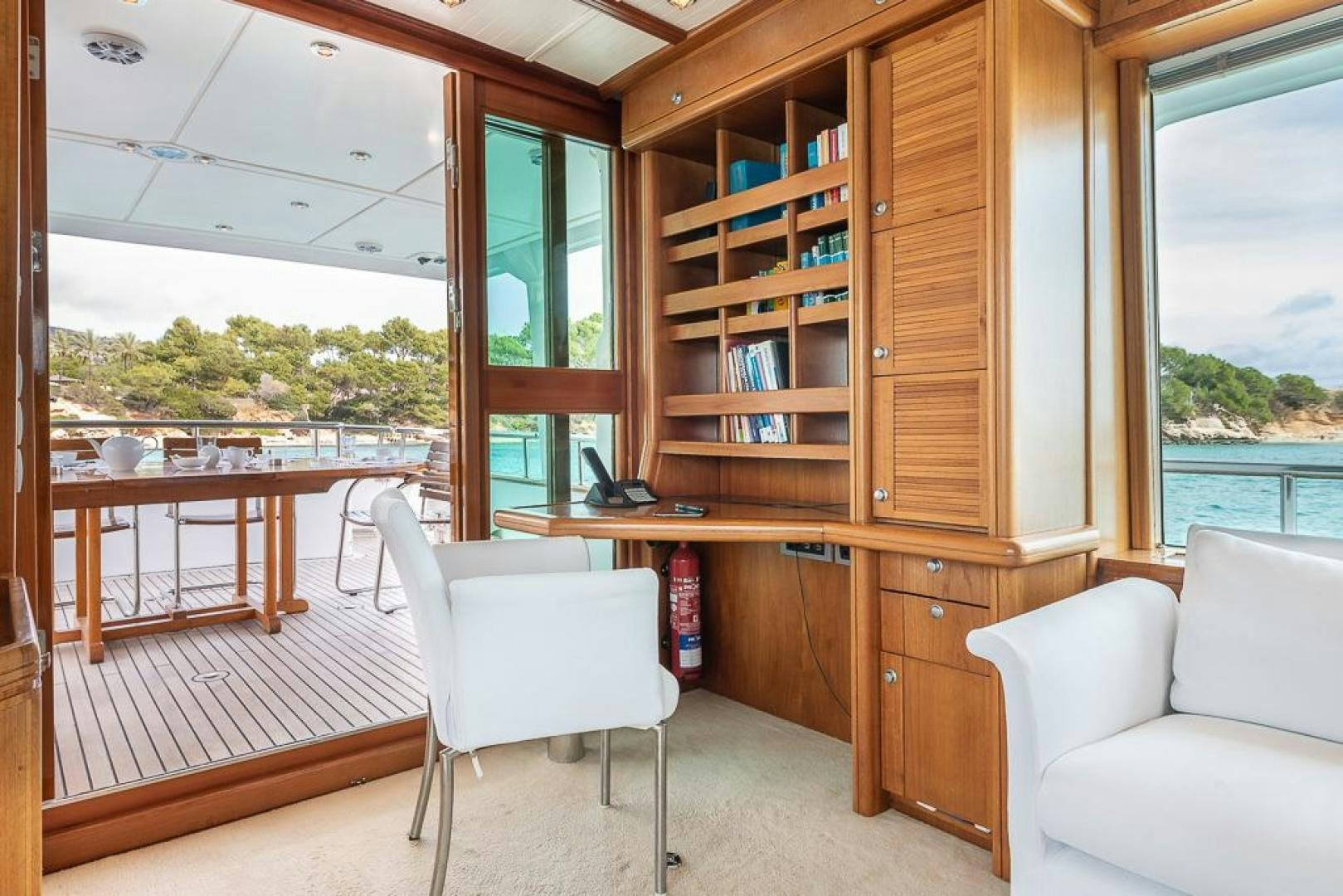 a room with a wood shelf and a white chair and a white chair aboard CAPELLA Yacht for Sale