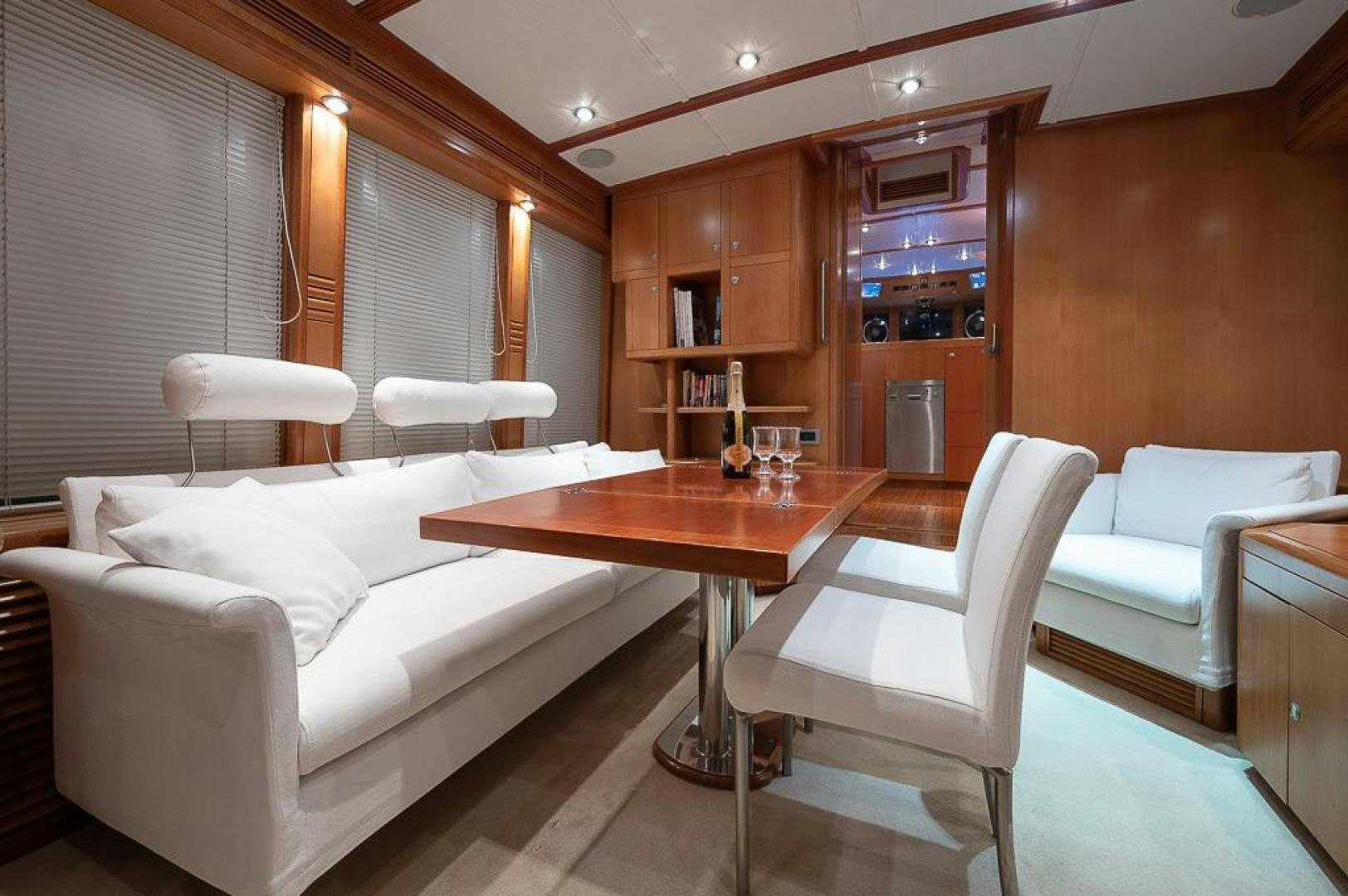 a living room with a table and couches aboard CAPELLA Yacht for Sale